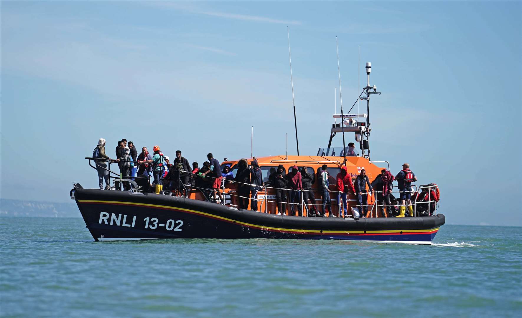 A group of people, thought to be migrants, who were towed into Kent in August (Jordan Pettitt/PA)