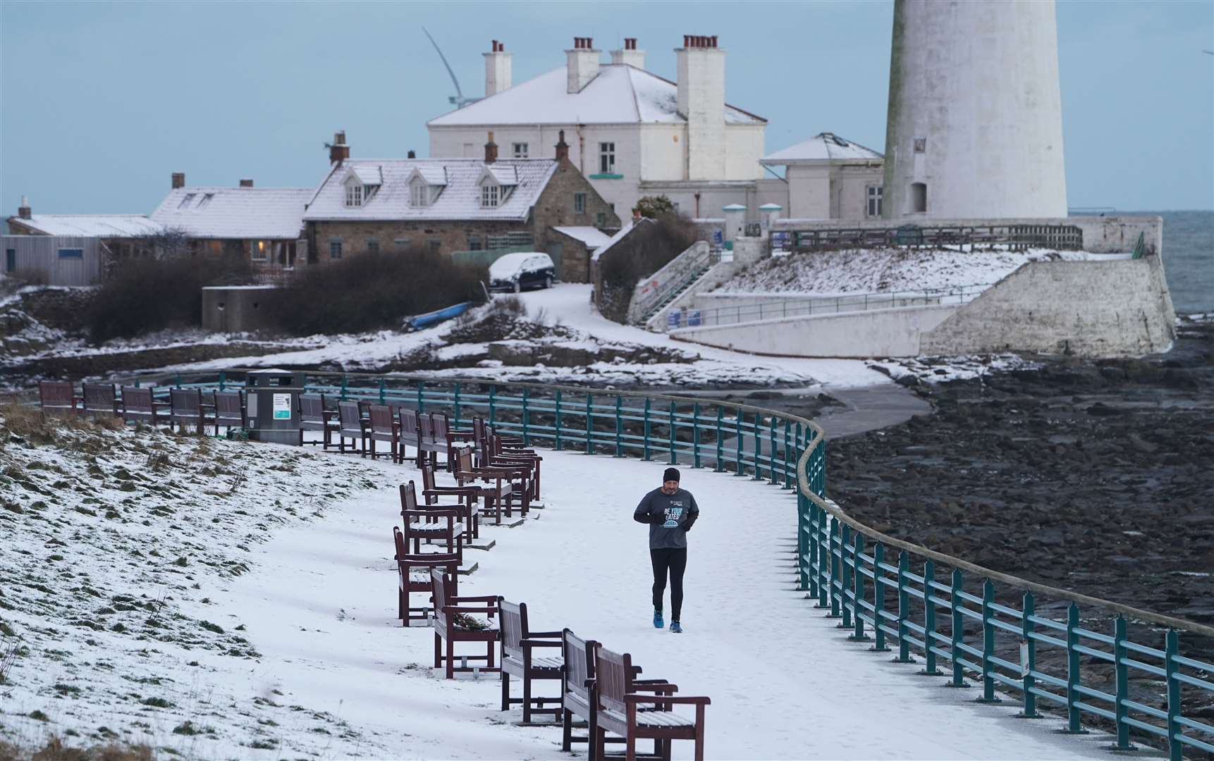 A person runs past St Mary’s Lighthouse near Whitley Bay (Owen Humphreys/PA)