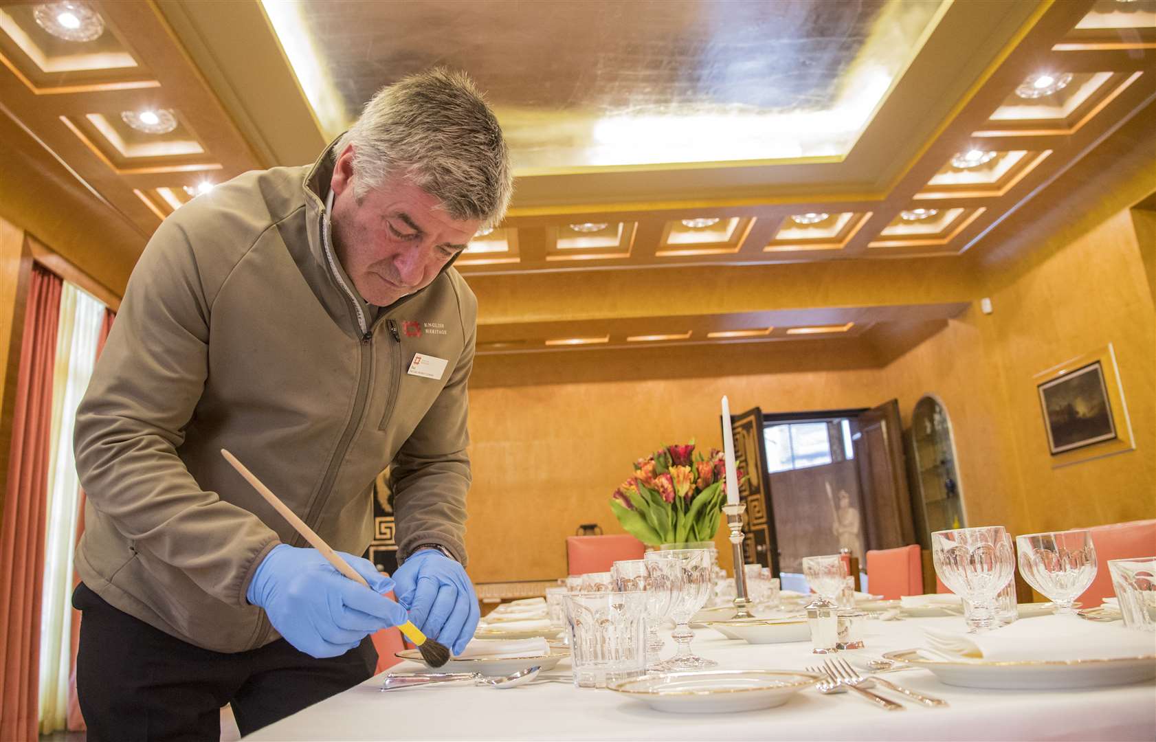 Paul Fretwell cleans the silver in the Dining Room at Eltham Palace in London (Ian West/PA)