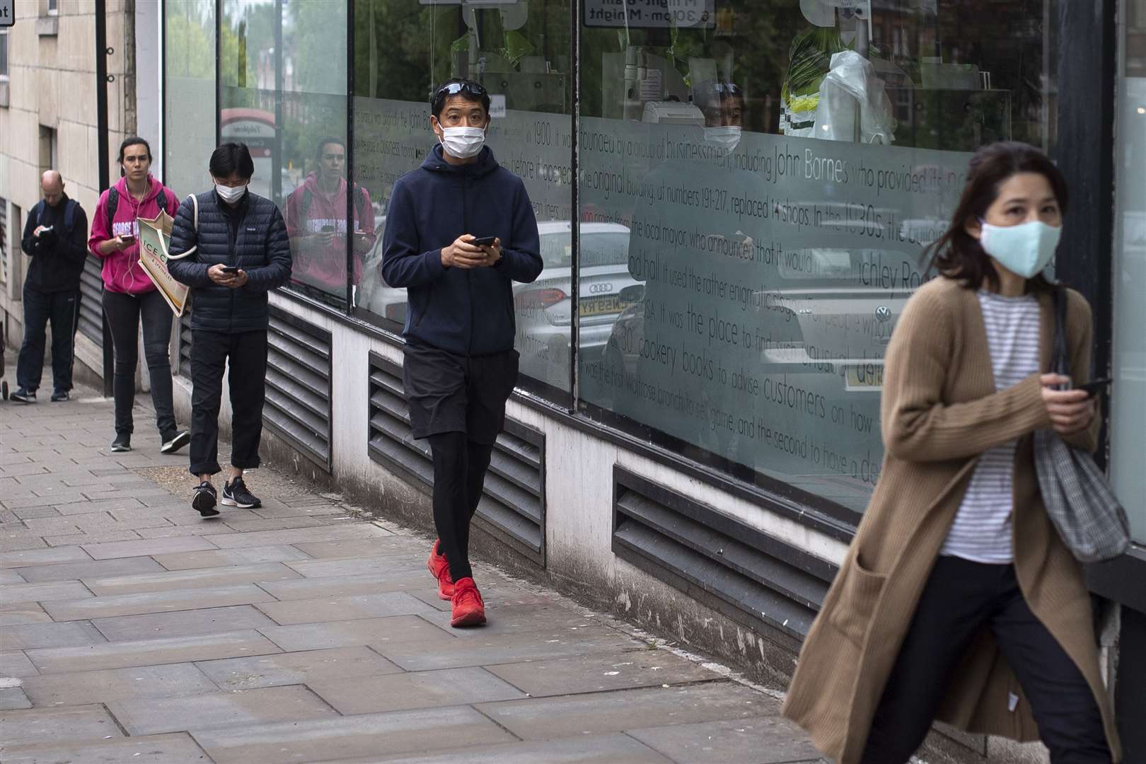 Customers maintain social distancing in a queue to enter a Waitrose supermarket (Victoria Jones/PA Images)