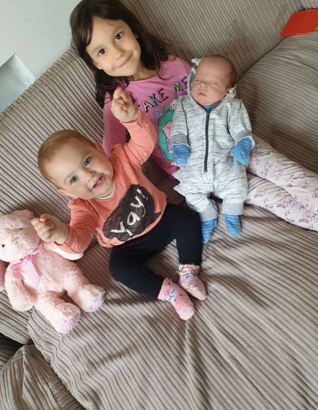 Sisters Anna-Karina and Anna-Karla cuddle up with their new baby brother Alexandru-Loachim Dutuc at their home in Castle Street, Queenborough