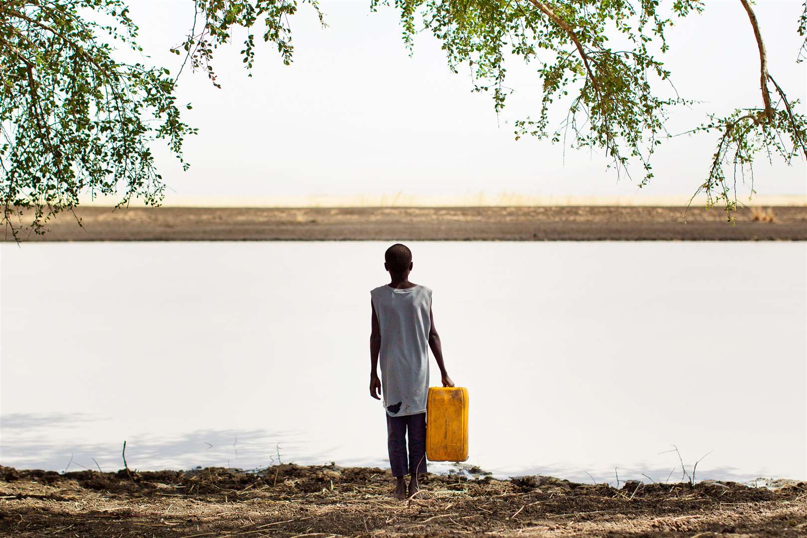 A boy gathers water beside a watering hole,in a remote area along the Sobat River in the Greater Upper Nile region of northeastern South Sudan (Julien Behal/AP)