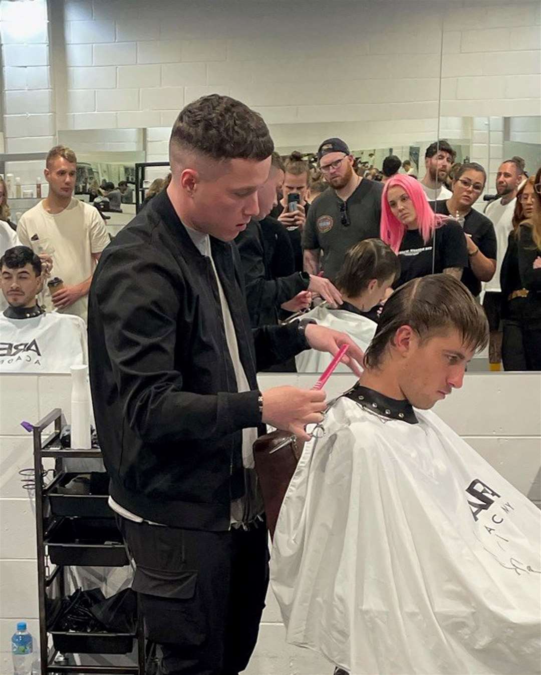 Mr Hawthorne giving a demonstration of his barbering skills (Mark Hawthorne/PA)