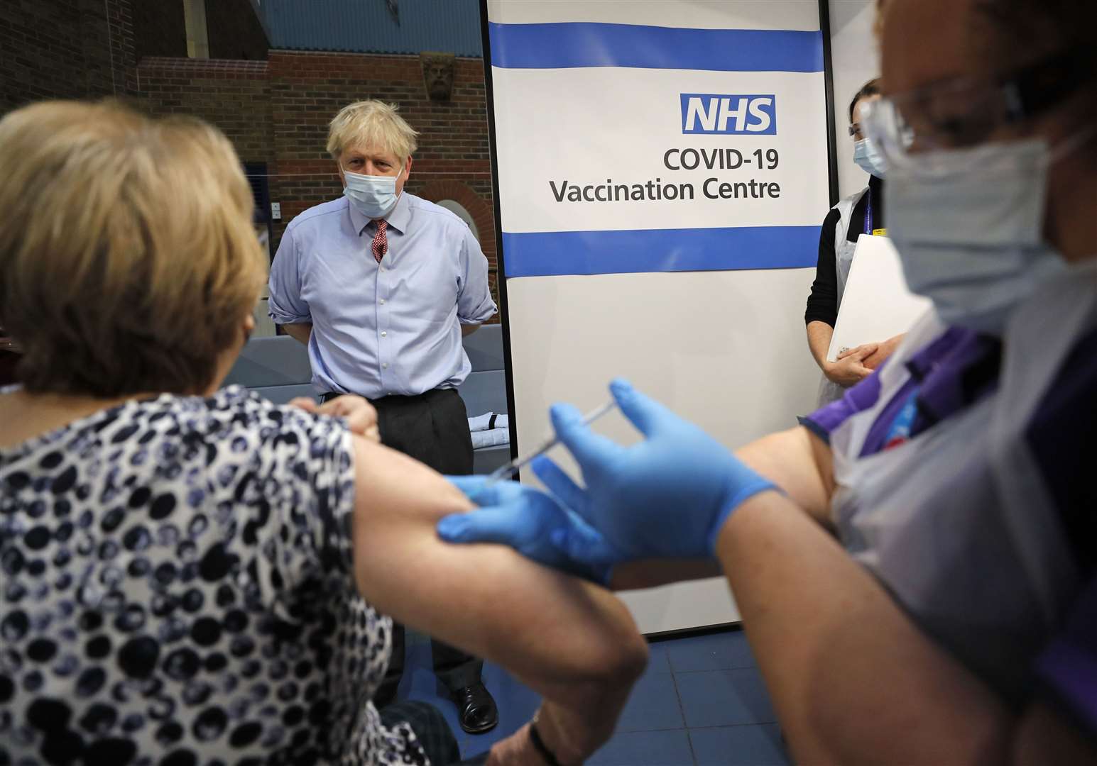 Prime Minister Boris Johnson watches as nurse Rebecca Cathersides gives the Pfizer/BioNTech vaccine to Lyn Wheeler at Guy’s Hospital in London (Frank Augstein/PA)