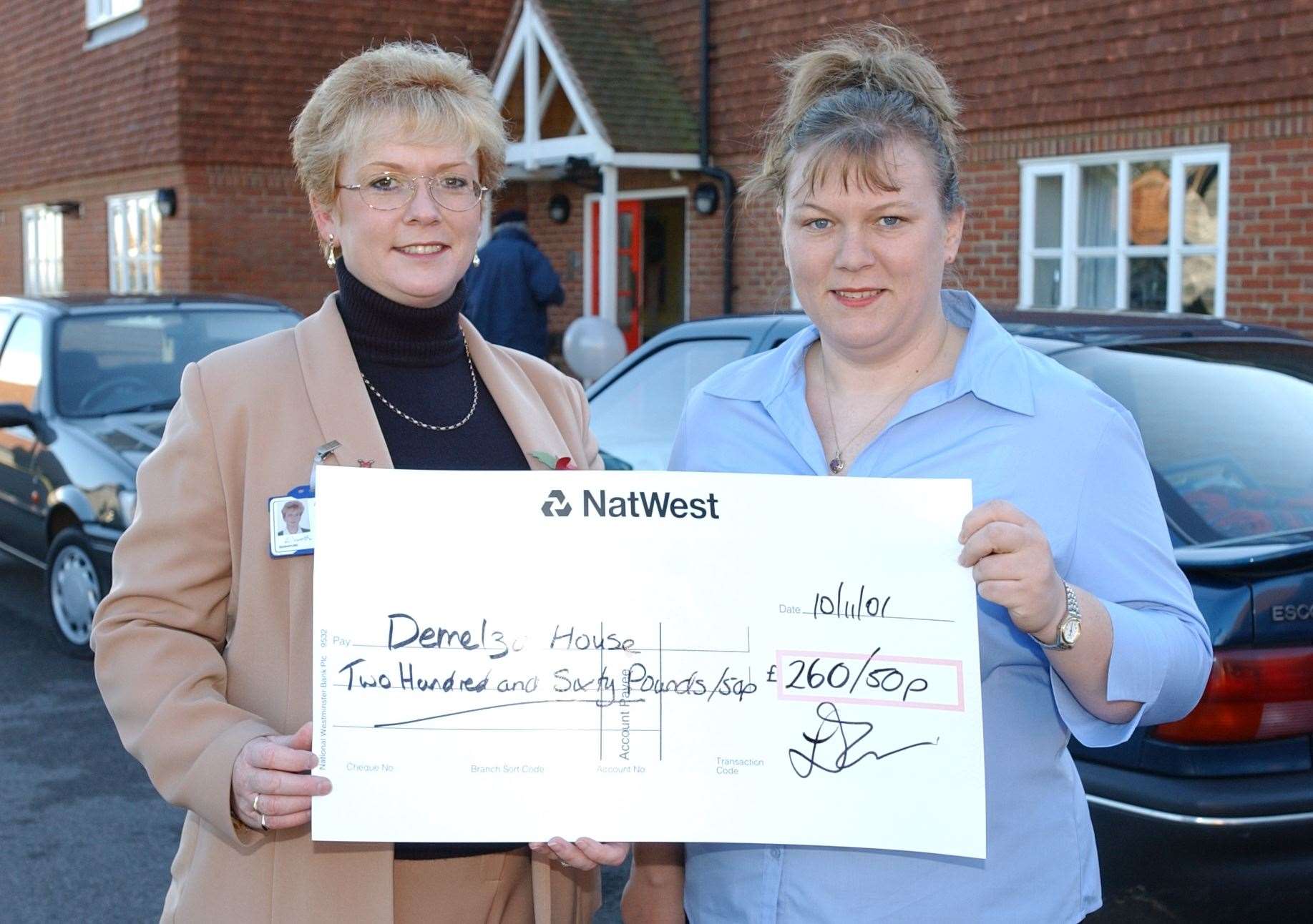 Lavinia posing for a photo after receiving a cheque for the charity in 2001