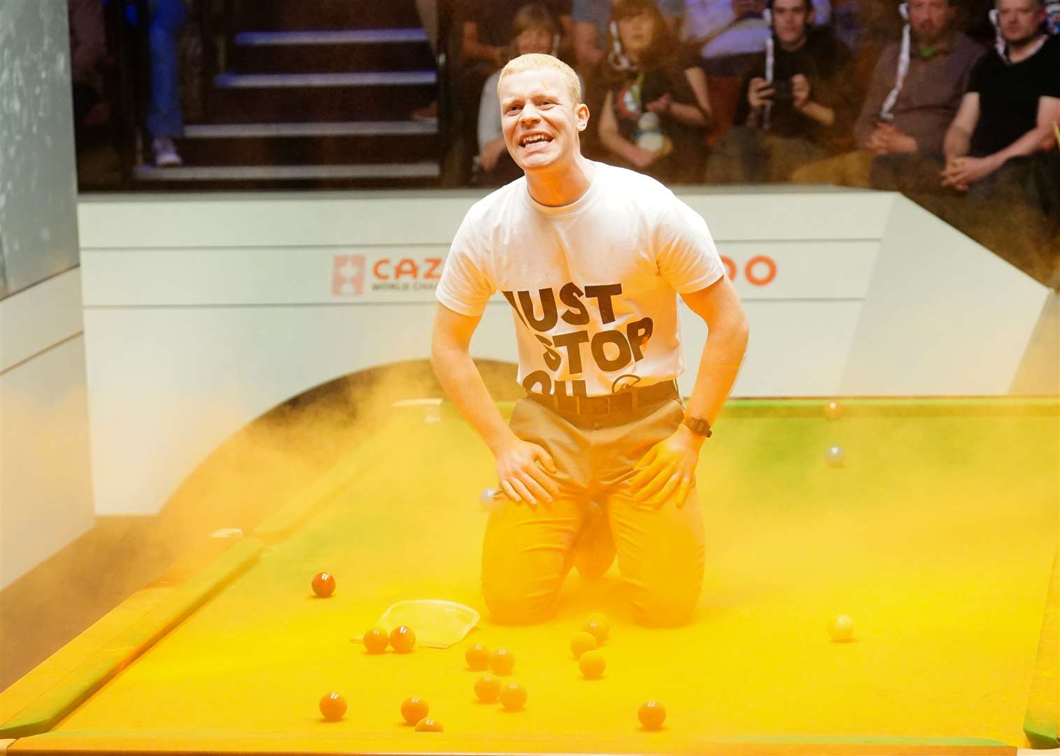 A Just Stop Oil protester after jumping onto a table and throwing orange powder at the World Snooker Championship (Mike Egerton/PA)