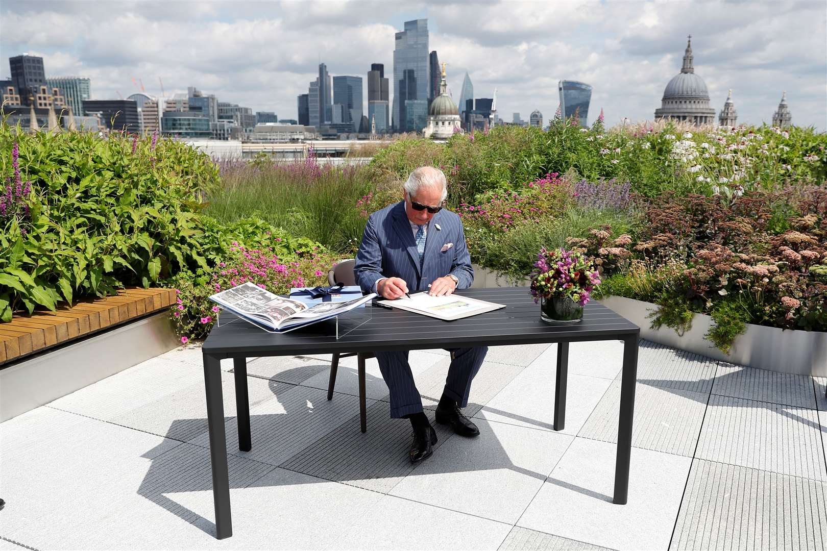 The Prince of Wales signs a document commemorating his visit to Goldman Sachs in central London (Peter Nicholls/PA)