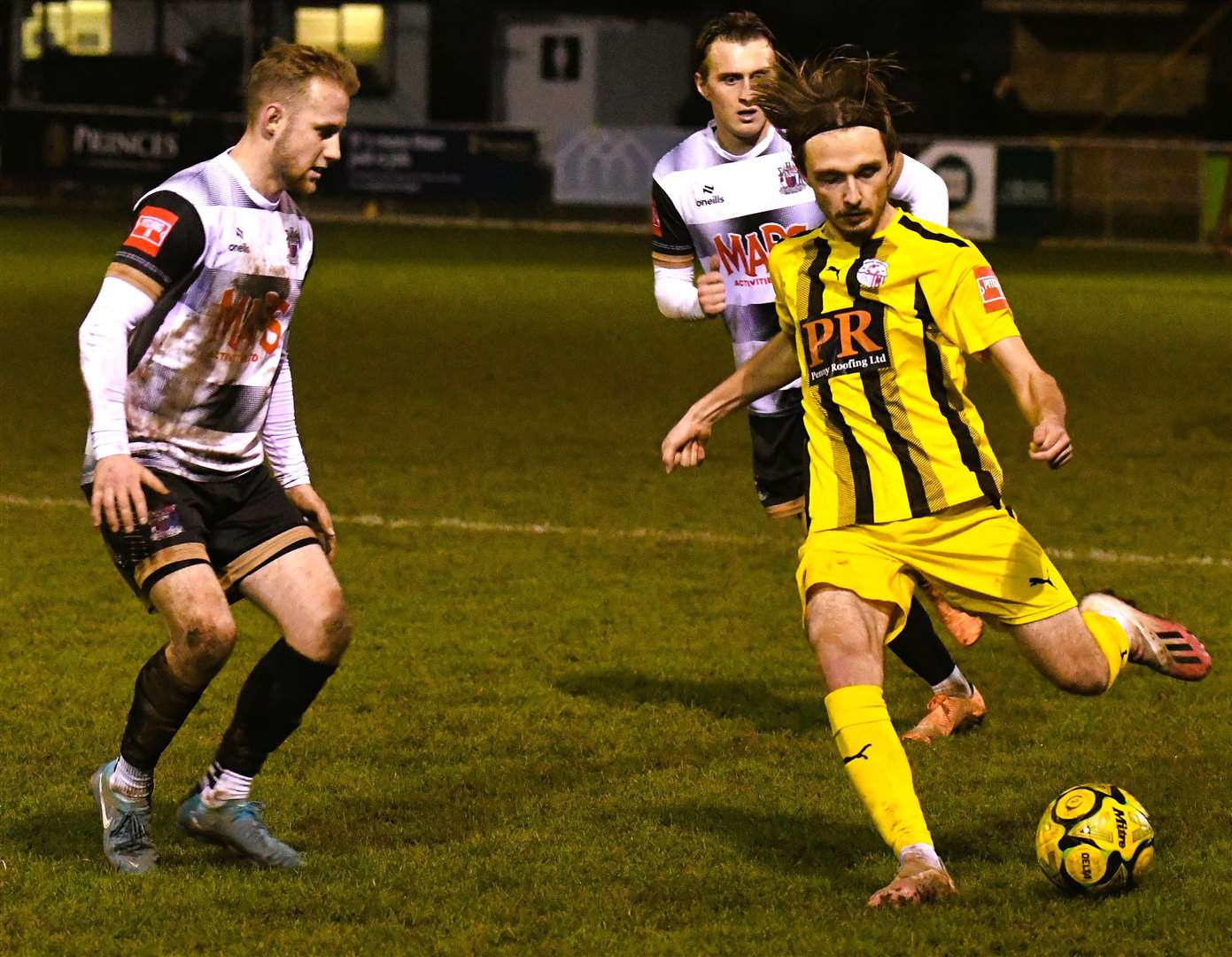 Jacob Lambert clips the ball forward for Sheppey despite being put under pressure from Deal defender Jack Paxman. Picture: Marc Richards