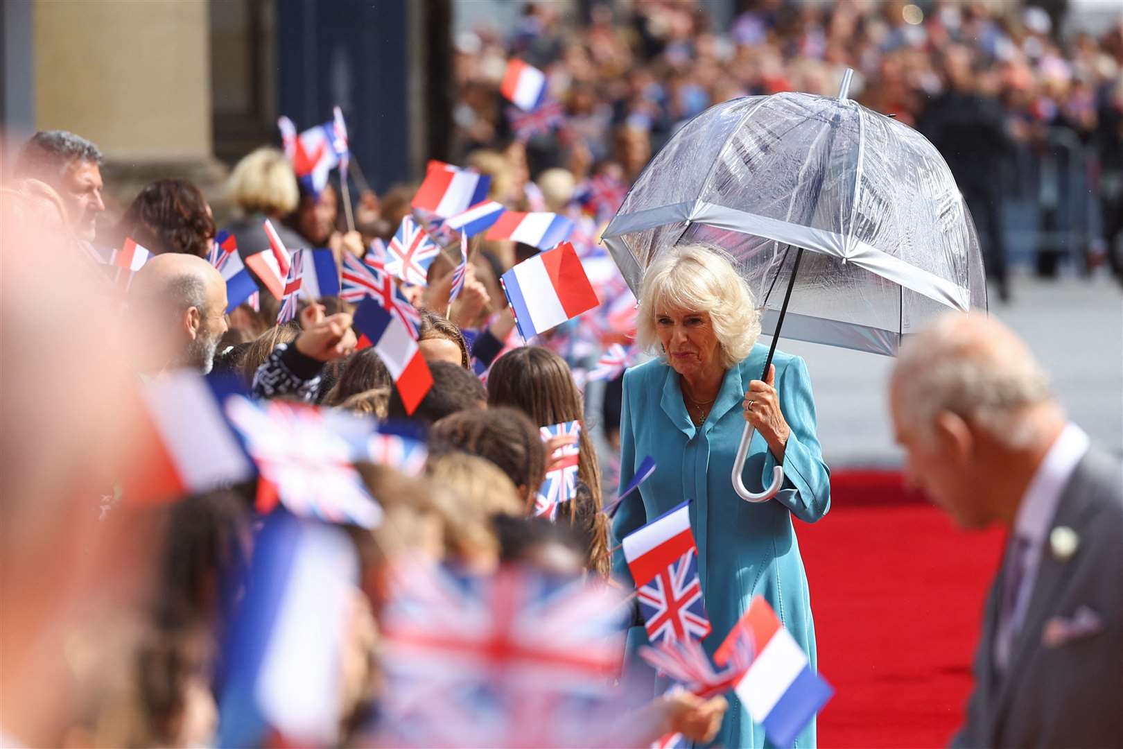 Despite the rain, the Queen stopped to say hello to some of the people who had waited to meet her and the King (Hannah McKay/PA)