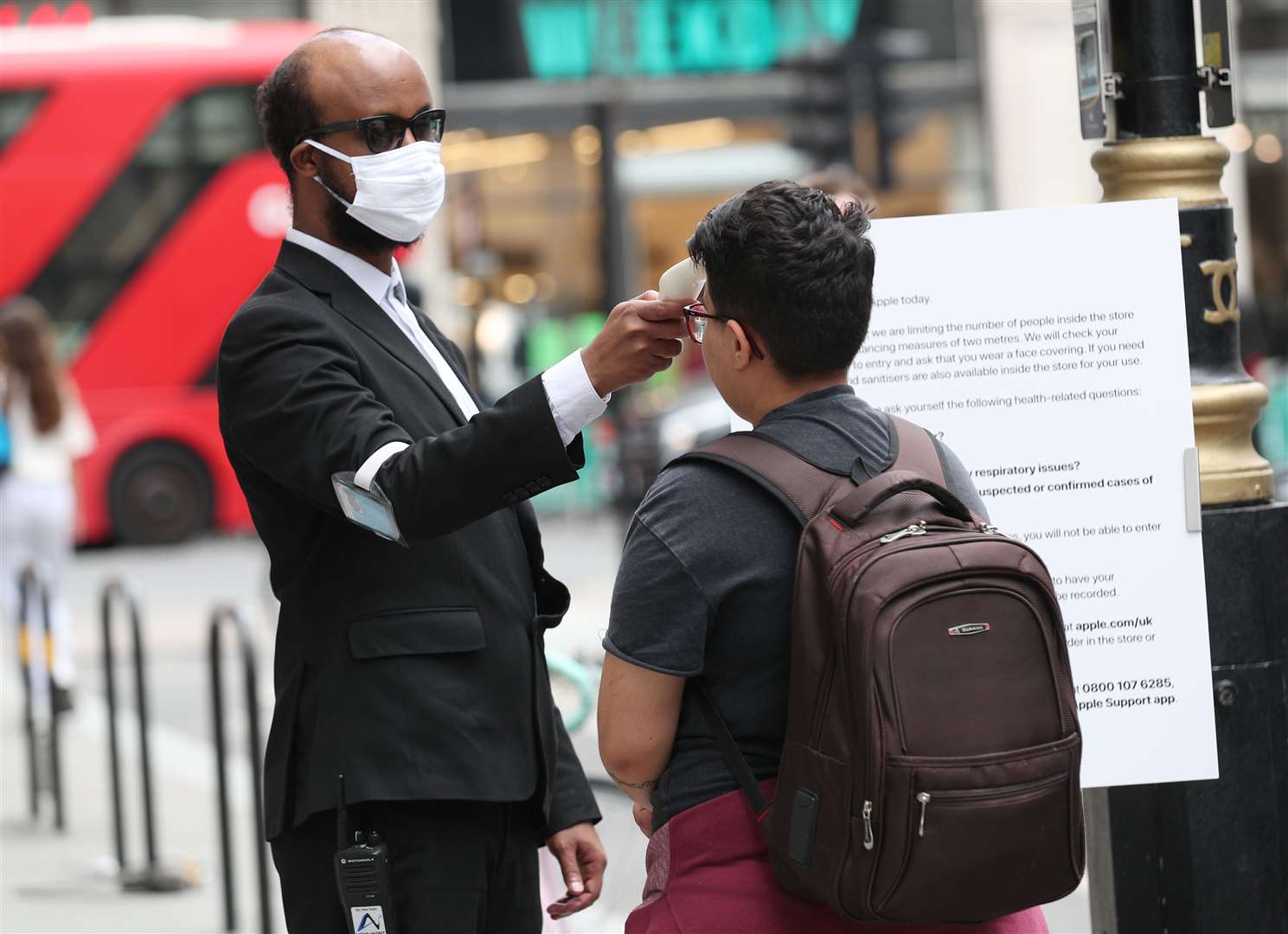 Customers have their temperature checked by staff before entering the Apple store (Yui Mok/PA)