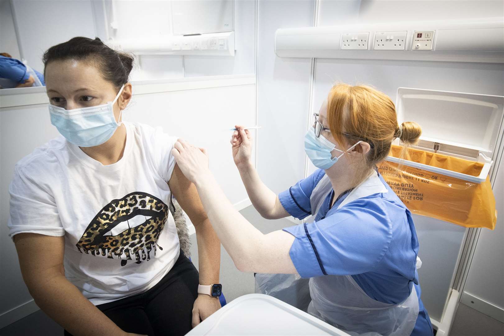 Nurse Eleanor Pinkerton administers a coronavirus vaccine to one of the health and social care staff at the NHS Louisa Jordan Hospital in Glasgow (Jane Barlow/PA)