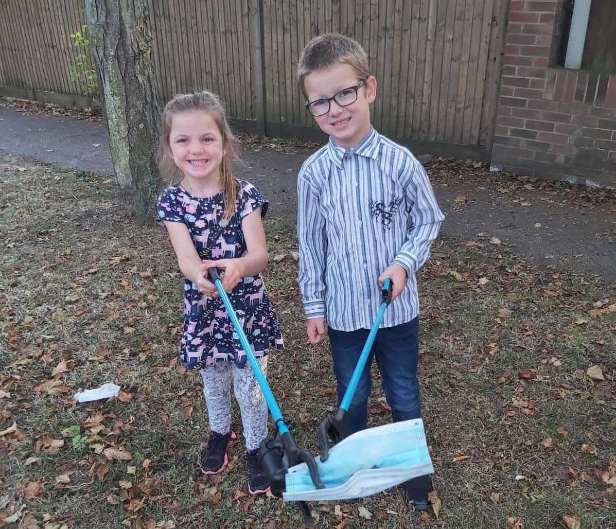 Daisy, four, and Jamie, six, collecting masks people have thrown on the floor