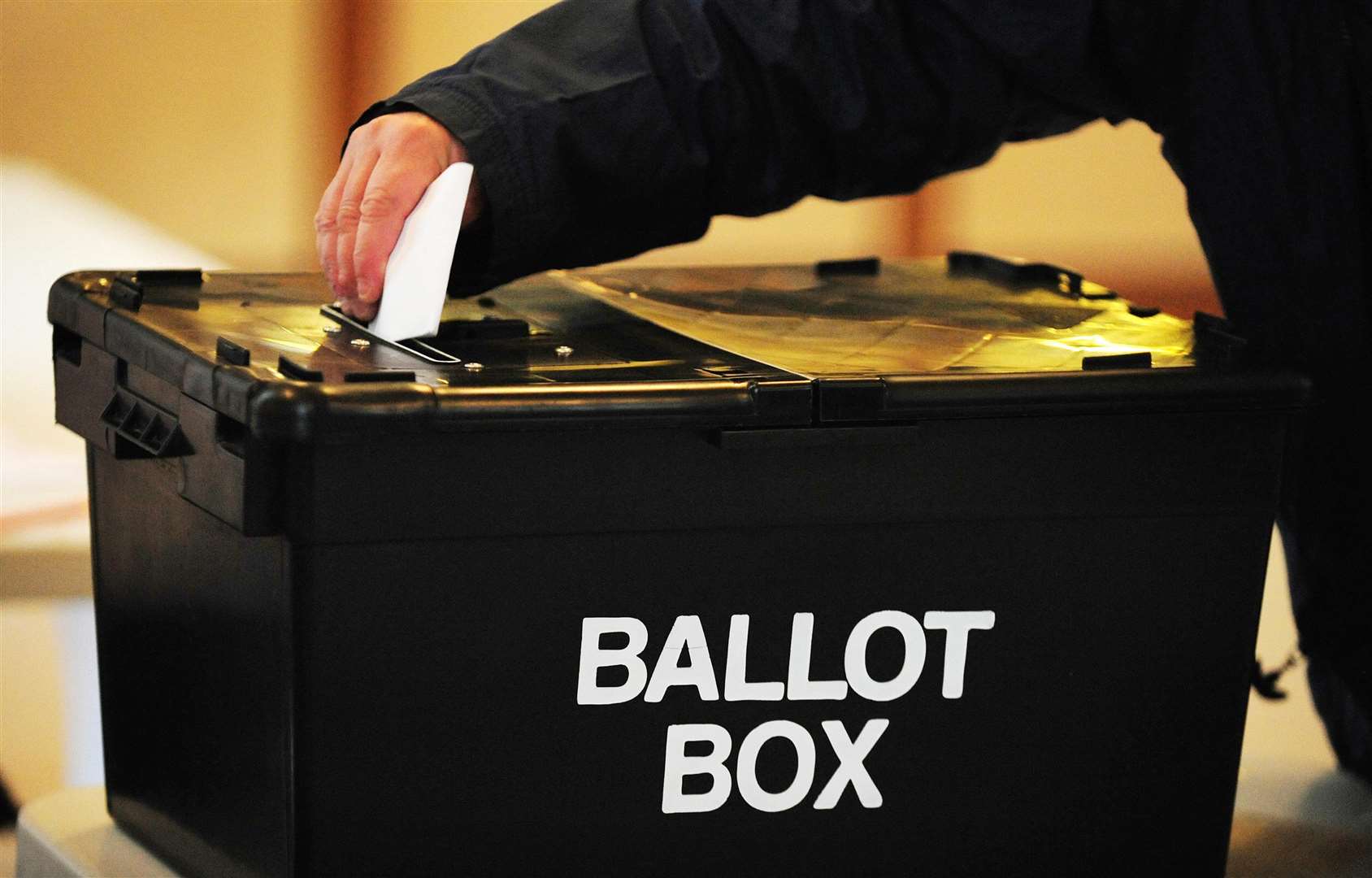 A voter places a ballot paper in a ballot box (Rui Vieira/AP)