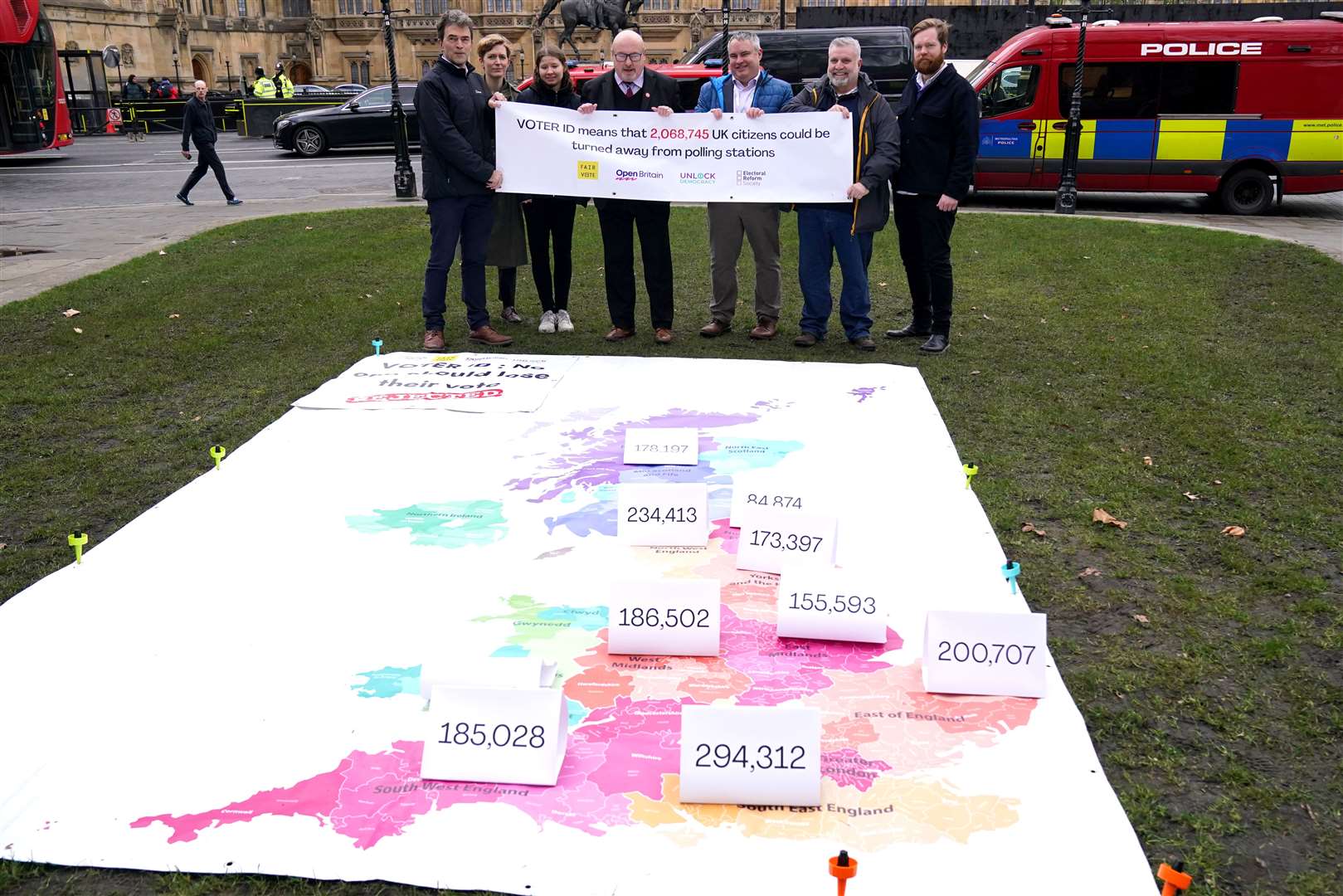 Labour MP Grahame Morris, fourth from left, joins campaigners unveiling a giant map outside the Houses of Parliament in Westminster, London, showing the numbers of voters at risk of being turned away from polling stations because of the voter ID rollout (Jonathan Brady/PA)