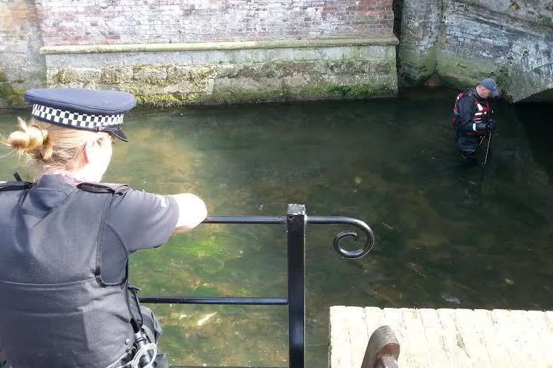 An officer watches as search for knife continues