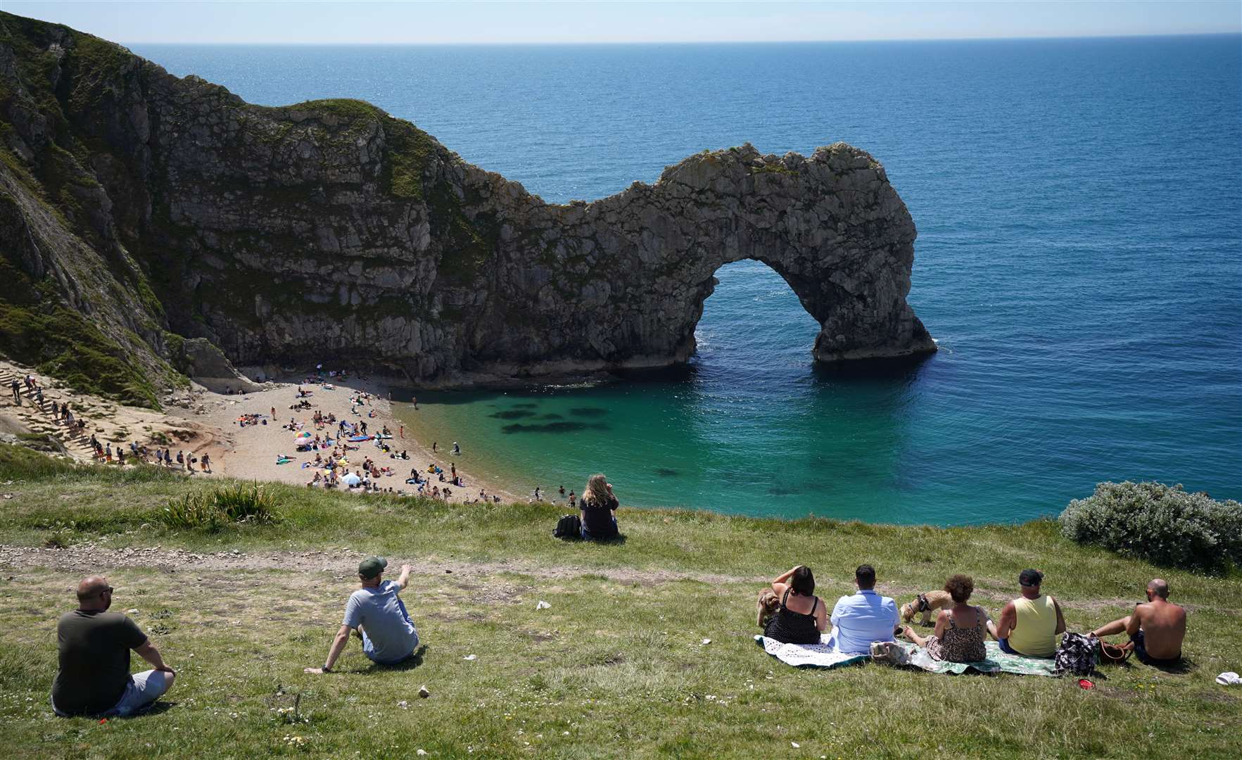 People enjoy the warm weather at Durdle Door in Dorset (Andrew Matthews/PA)