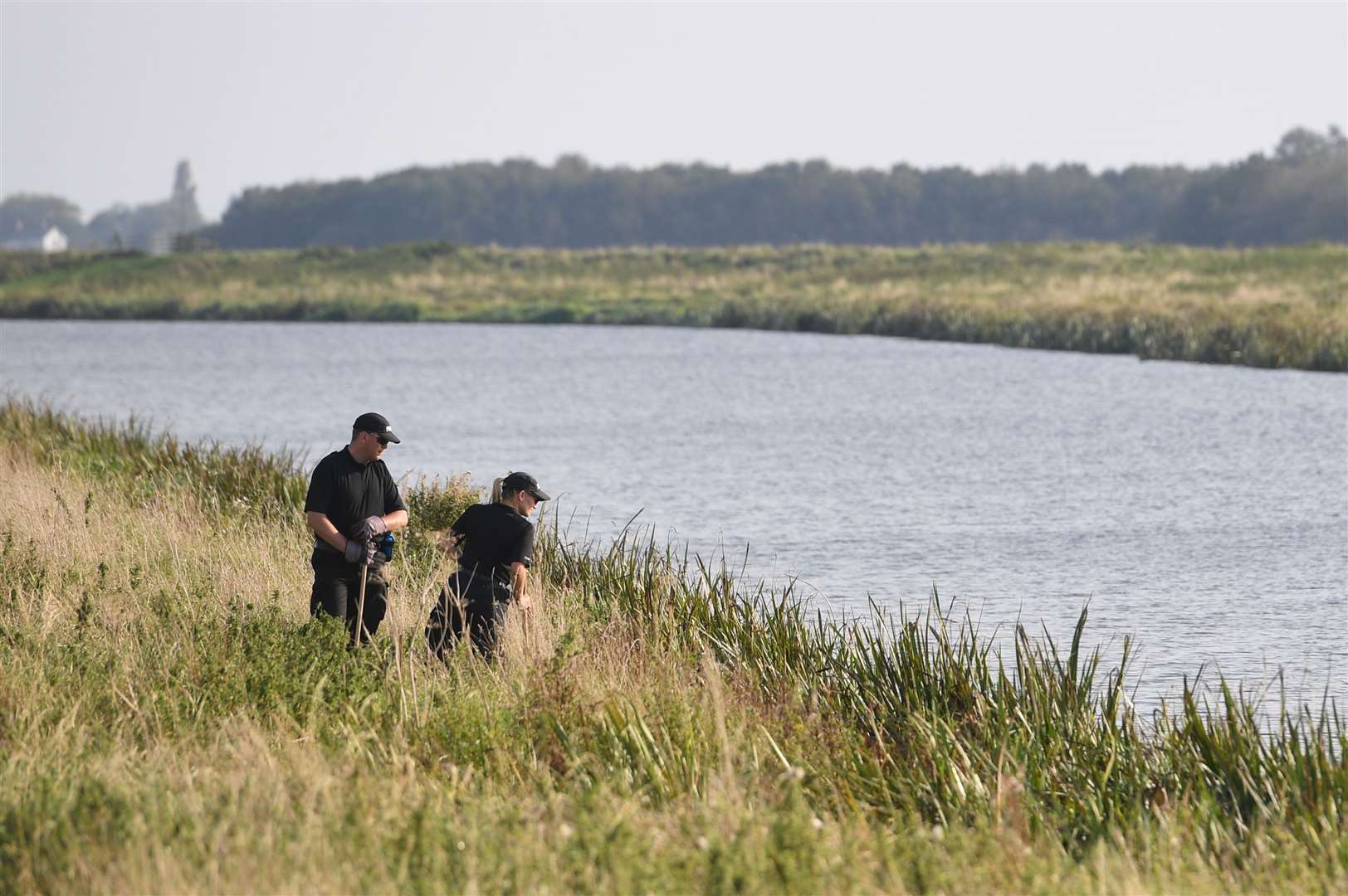 Two police officers on the bank of the river Welland (Joe Giddens/PA)