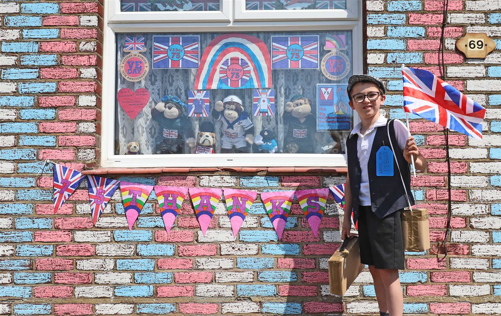 Alex Glover, 10, dressed as a Second World War evacuee outside his home in Sittingbourne, Kent, where he has created a VE Day theme which includes a tribute to 100-year-old Captain Tom Moore (Gareth Fuller/PA)