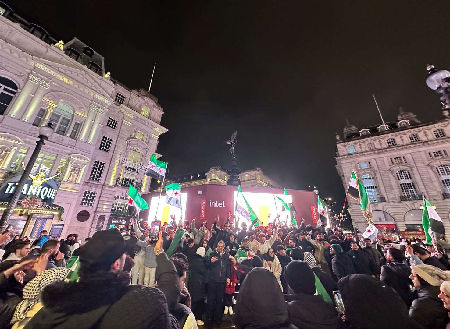 Syrian gathered in Piccadilly Circus, London, to celebrate the fall of the Assad regime (Zouhir Al-Shimale/PA)