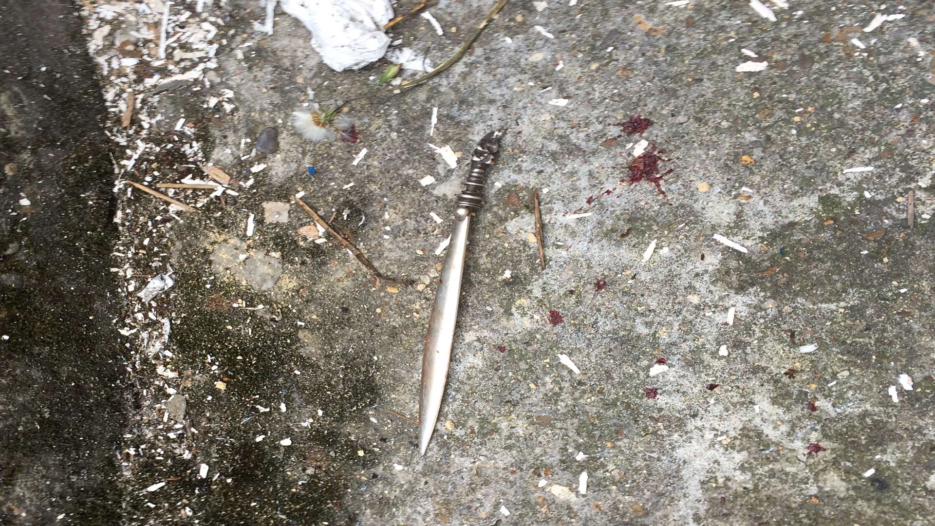 A knife found at the scene of the crime with a splatter of blood next to it