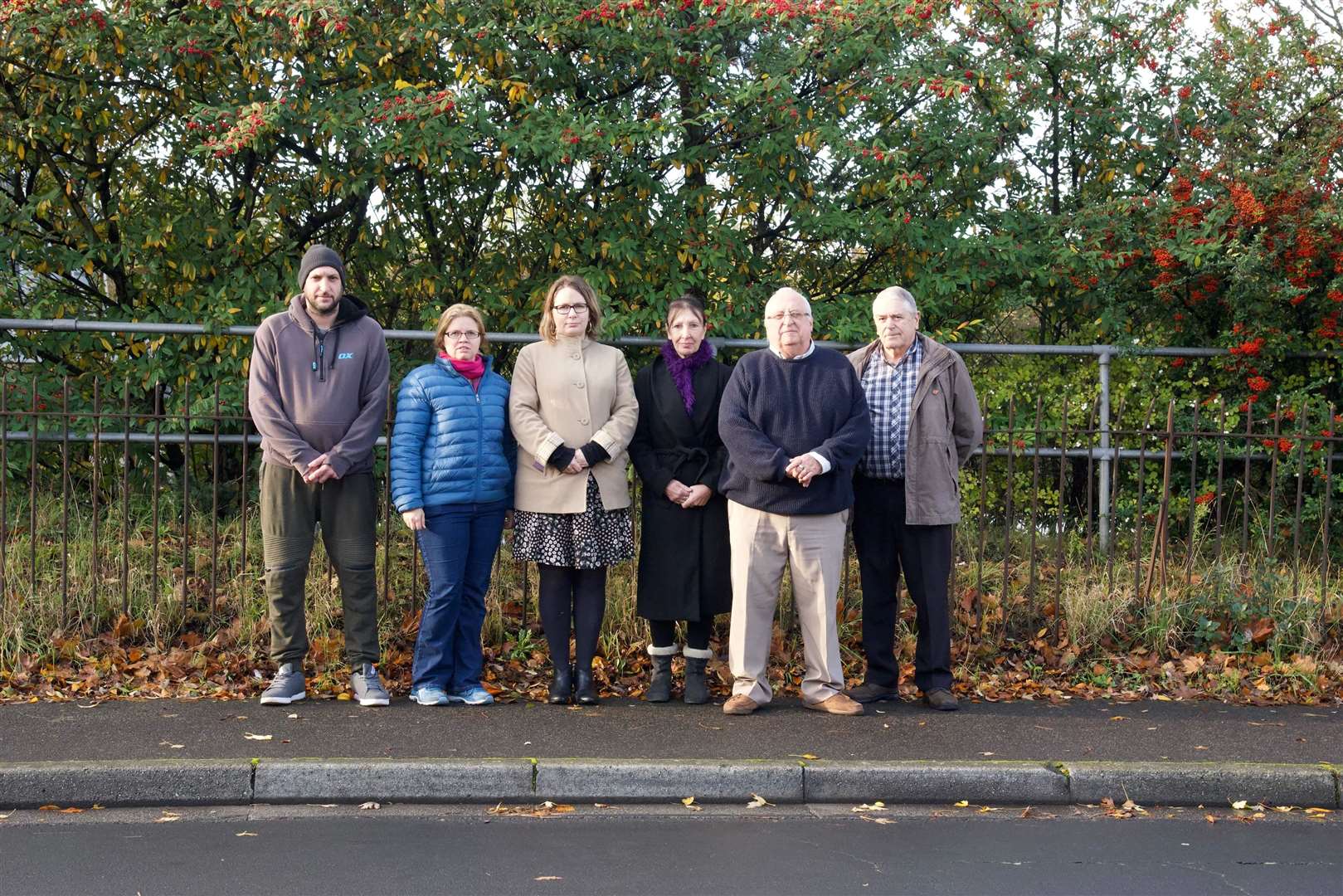 Residents of Brent Way gather outside the decaying fence which separates their houses from the motorway