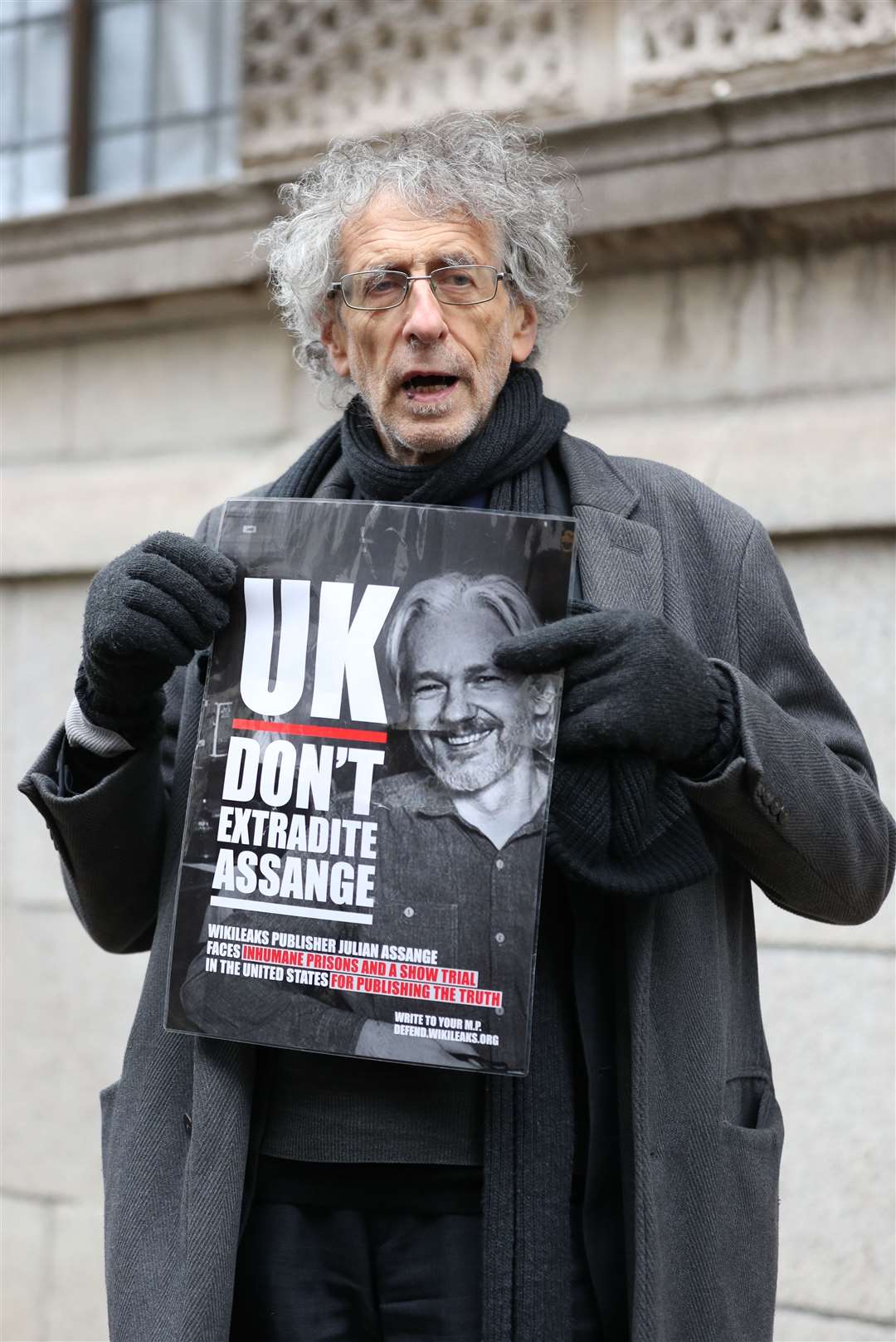 Piers Corbyn holds up a poster in support of Julian Assange outside the Old Bailey, London. (Yui Mok/PA)