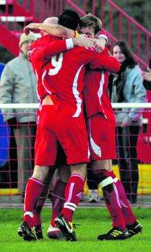 Hythe's Craig Thompson (number nine) is mobbed by his teammates after scoring against Merstham.