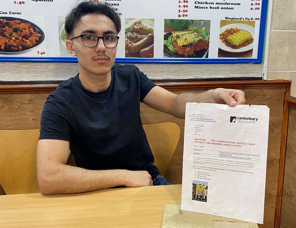 Mustafa Kovak, pictured with the council notice, says The Beano cafe has lost customers since having to repaint its colourful frontage and change its sign