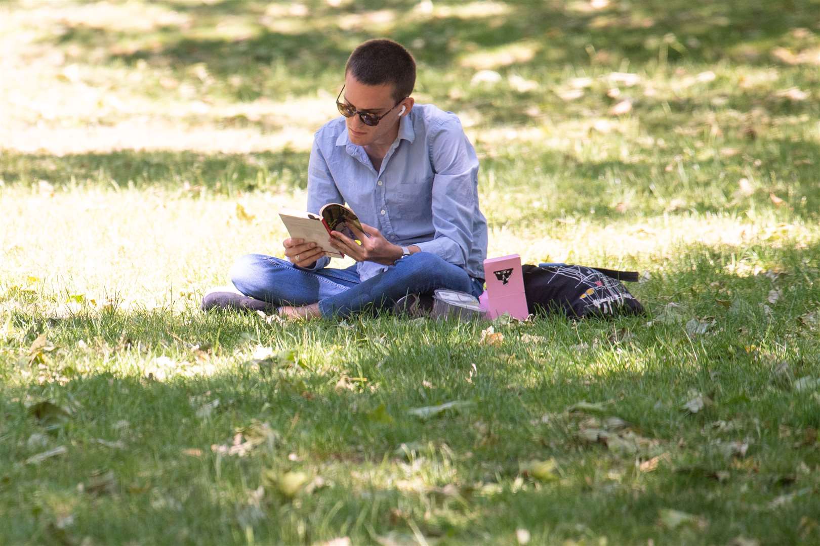 A man reads a book St James Park (Dominic Lipsinki/PA) 