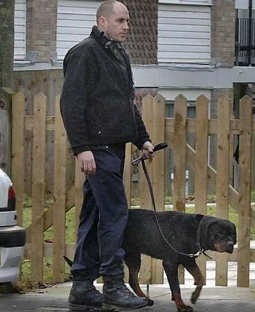 A police dog handler with one of the rottweilers believed to be responsible for the attack