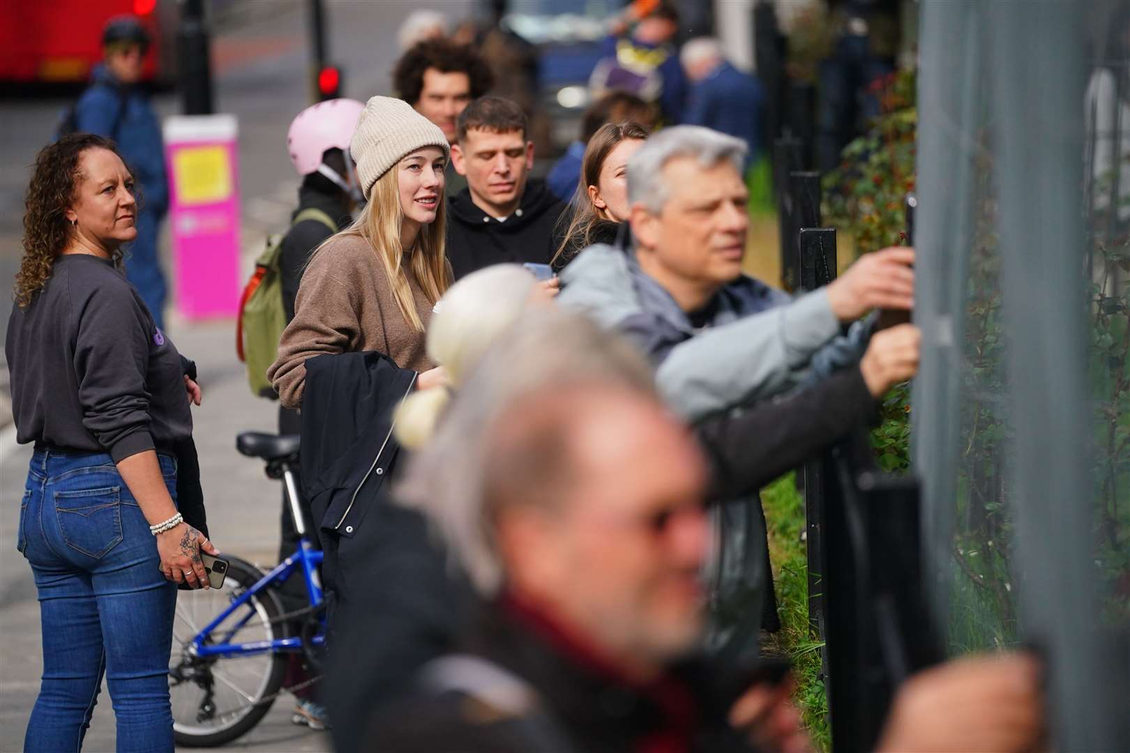 People looking at Banksy artwork which has been defaced with white paint (Victoria Jones/PA)