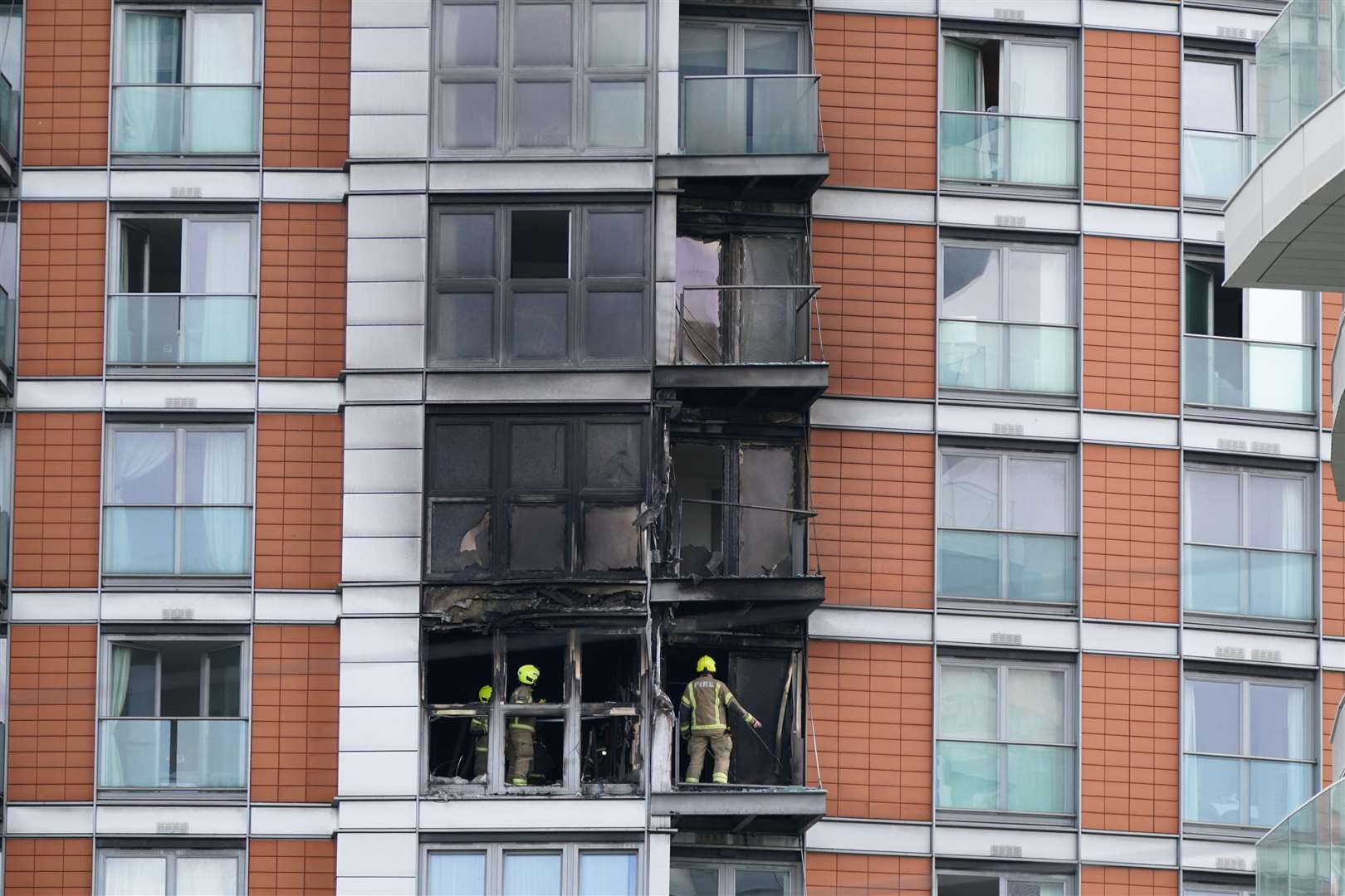 Firefighters inspect damage to the 19-storey tower block (Yui Mok/PA)