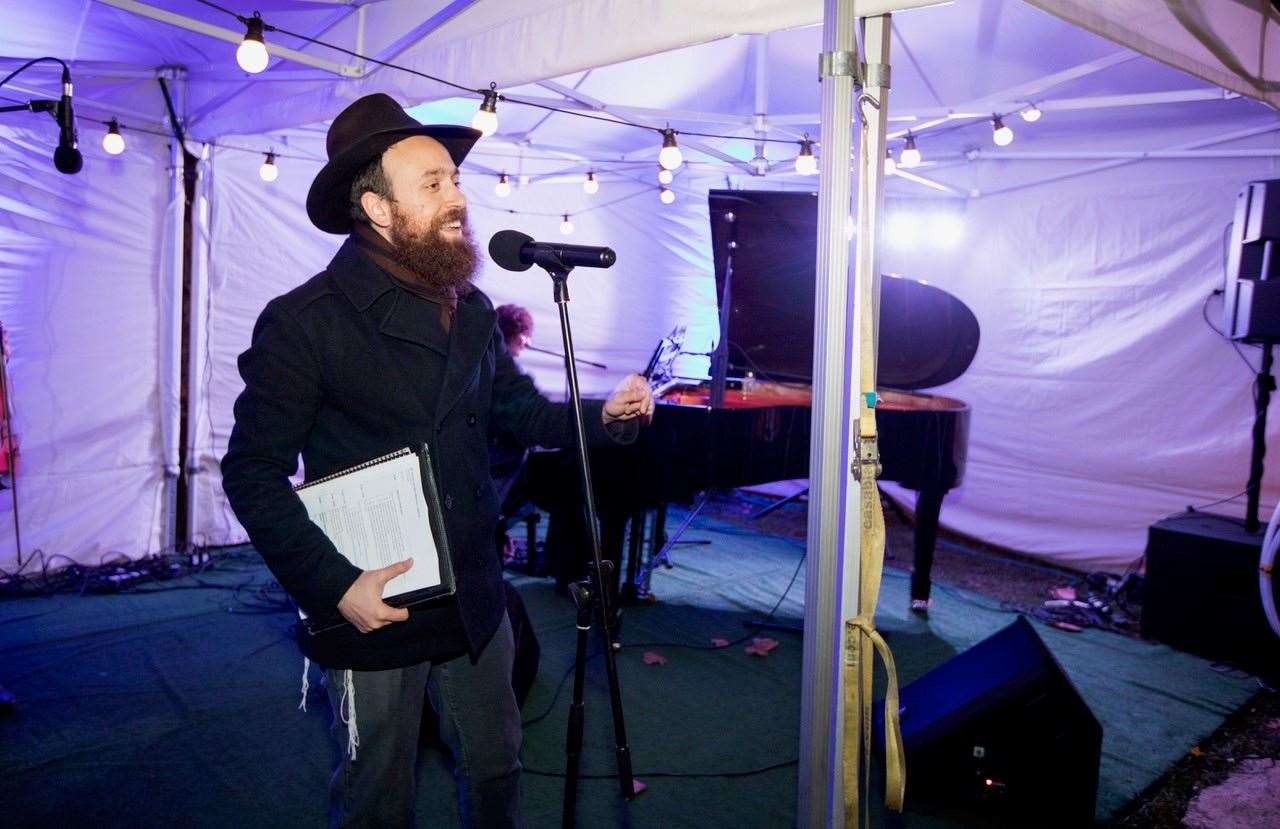 Rabbi Mendy Korer talking on stage at a previous Islington menorah lighting (Chabad Islington)