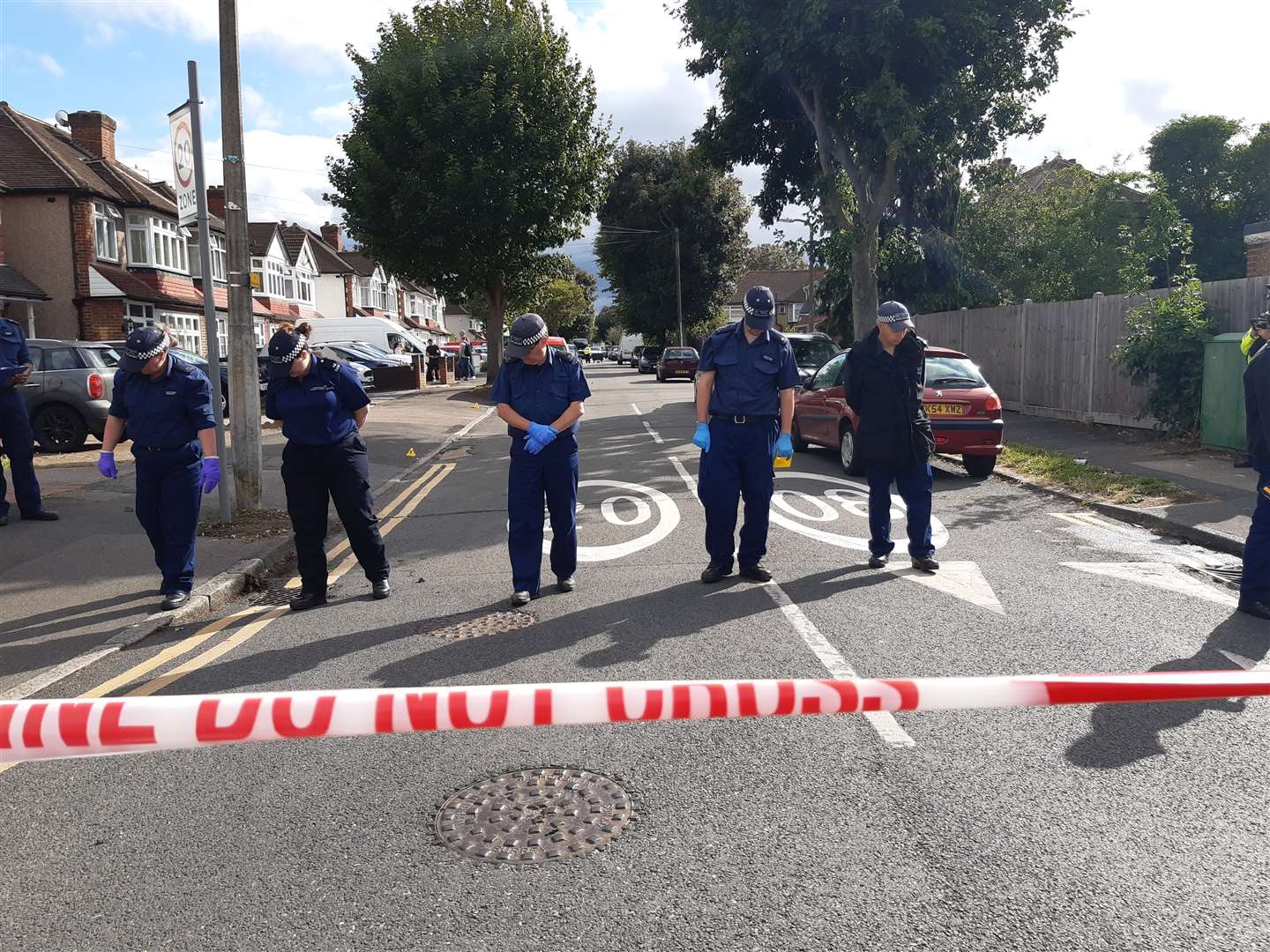 Lines of officers on Brocks Drive in North Cheam, as they carried out fingertip searches behind a cordon (Helen William/PA)