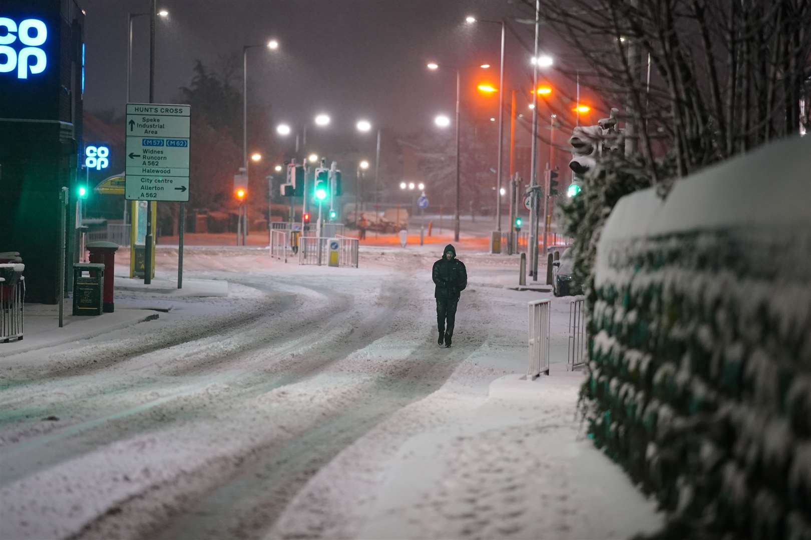 A person walks along a snow covered street (Peter Byrne/PA)