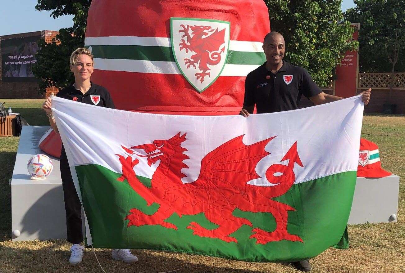 Welsh ambassadors Jess Fishlock and Colin Jackson at the giant bucket hat sculpture in Doha (PA)