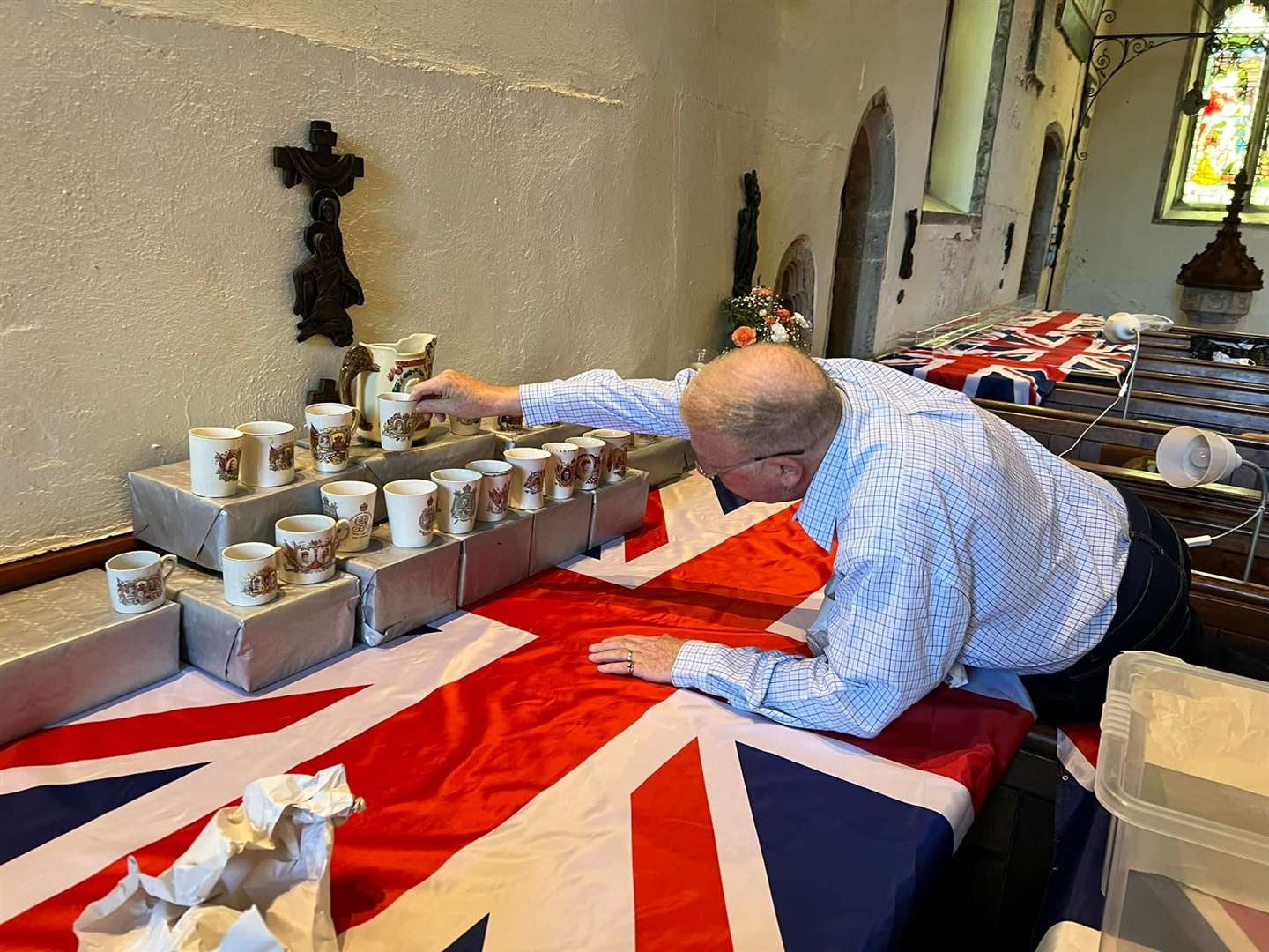 Chris Andrews examines some of mugs for a special exhibition of royal memorabilia at St Peter and St Paul's church at Borden for the Queen's Platinum Jubilee