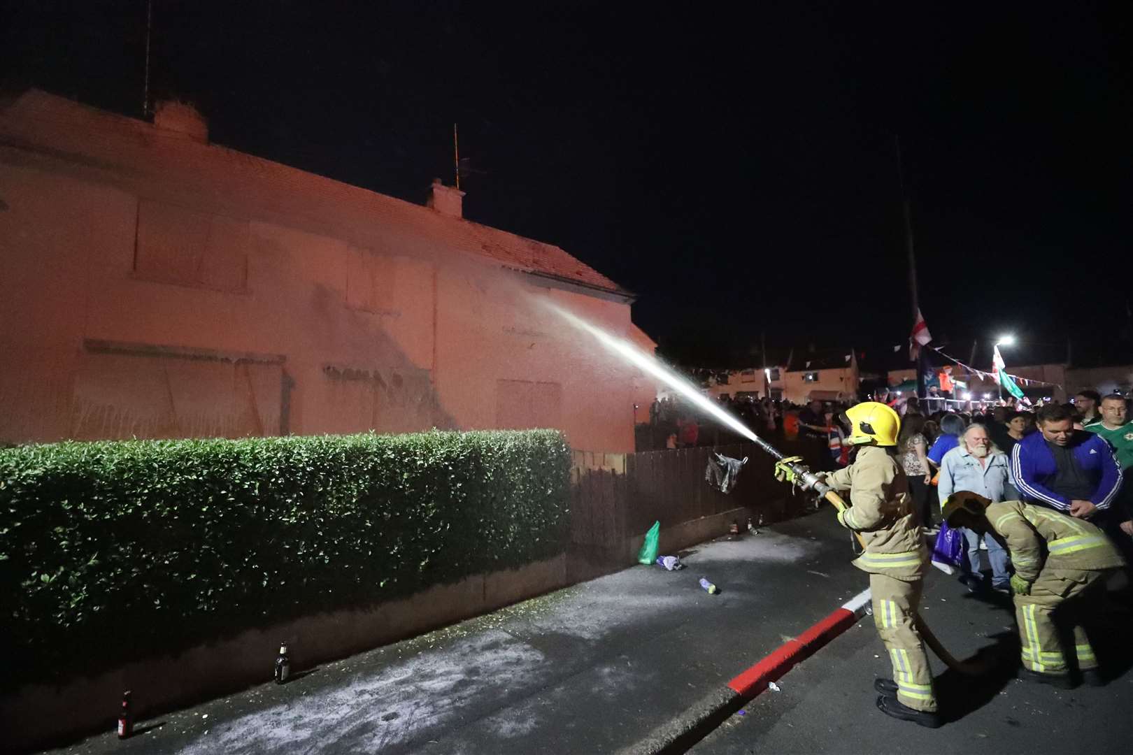 Firefighters dampen down nearby properties in the Corcrain area of Portadown (Niall Carson/PA)