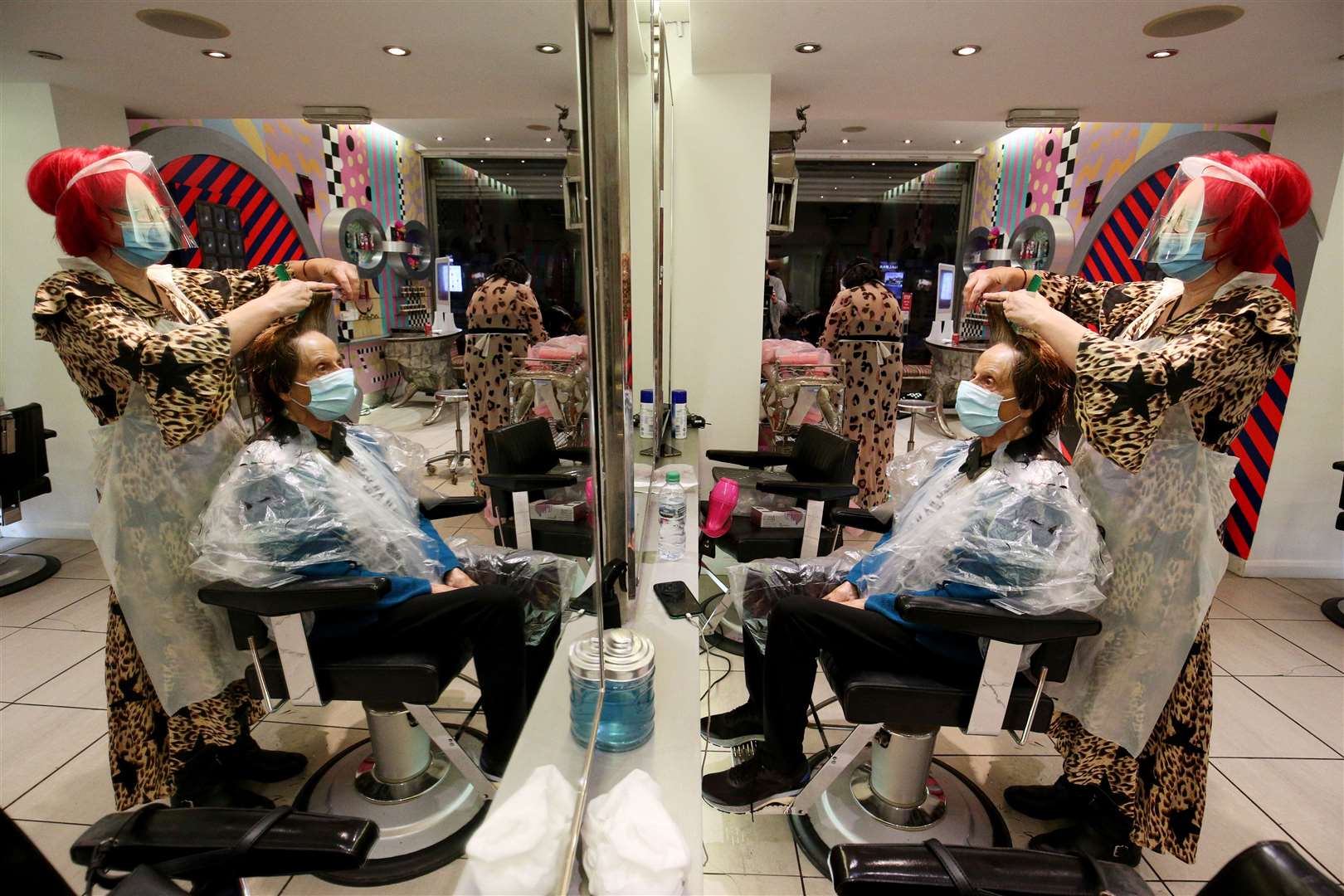 Carole Rickiby cuts the hair of customer Sandra Jacobs at Tusk Hair, in Camden, north London, after opening at midnight (Jonathan Brady/PA)