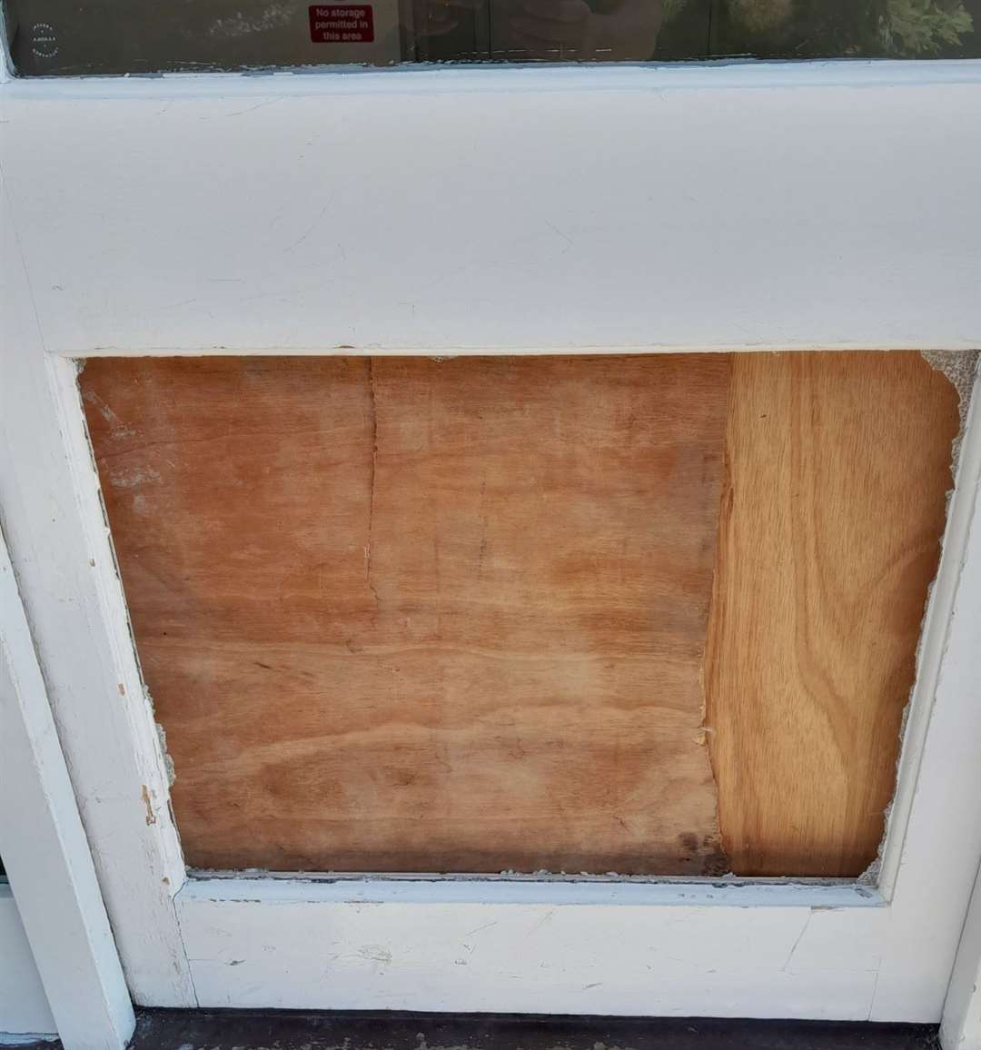 A broken glass panel and its temporary repair.