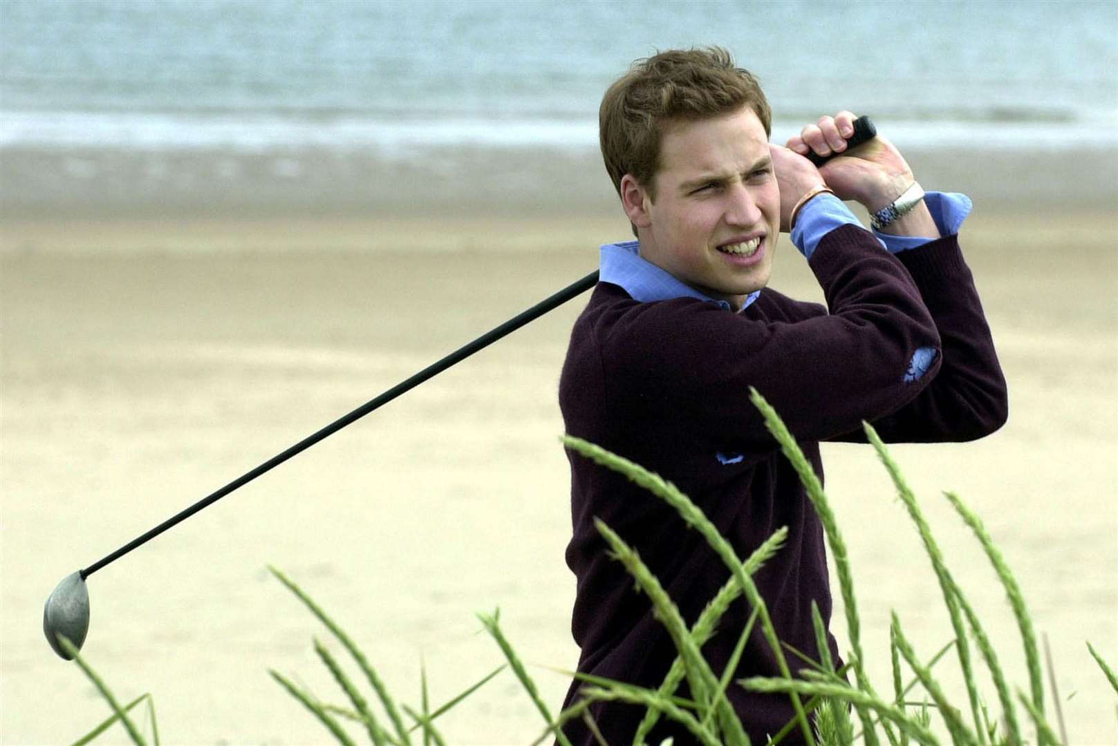 William throws a practice golf swing on the beach at St Andrews two years into his four-year History of Art degree (PA)