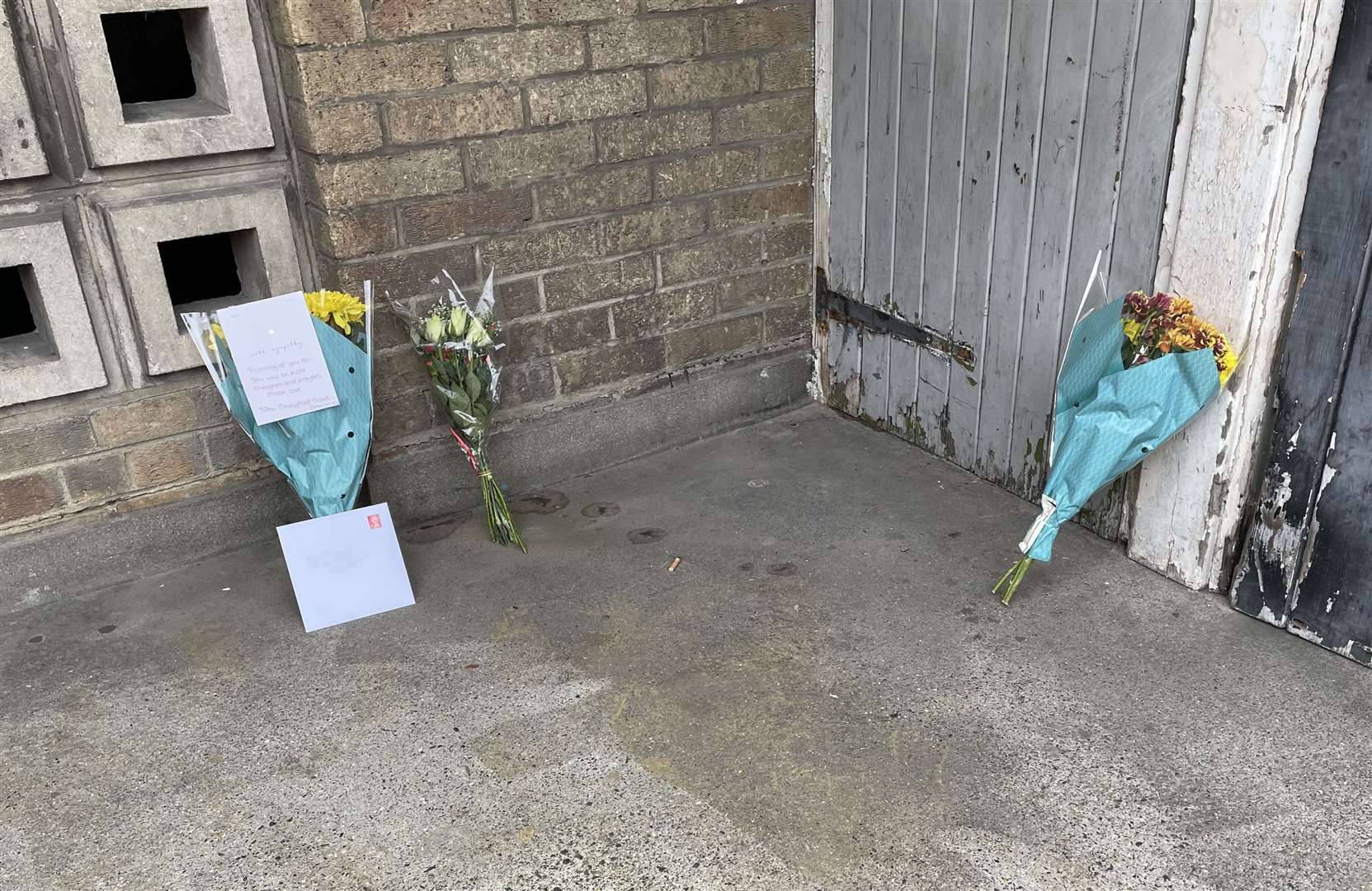 Floral tributes at the scene with address pixellated (Laura Parnaby/PA)