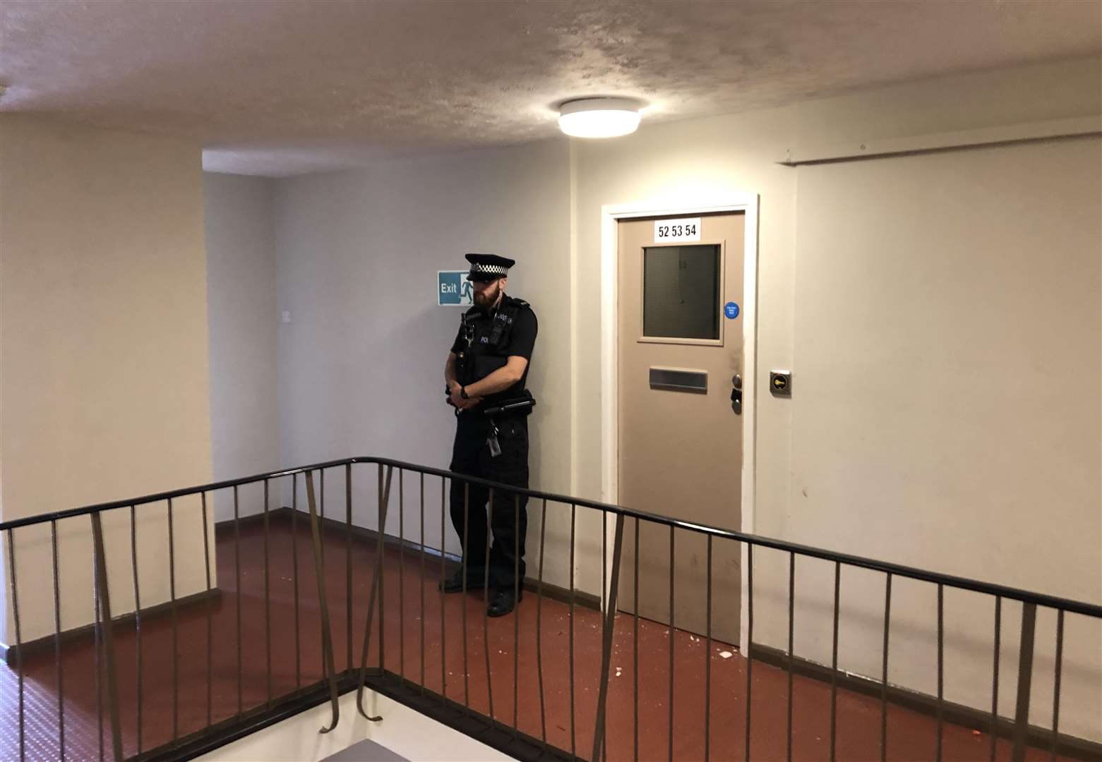 A police officer standing guard on Sunday outside the corridor of a top-floor flat in Basingstoke Road, Reading (Ben Mitchell/PA)