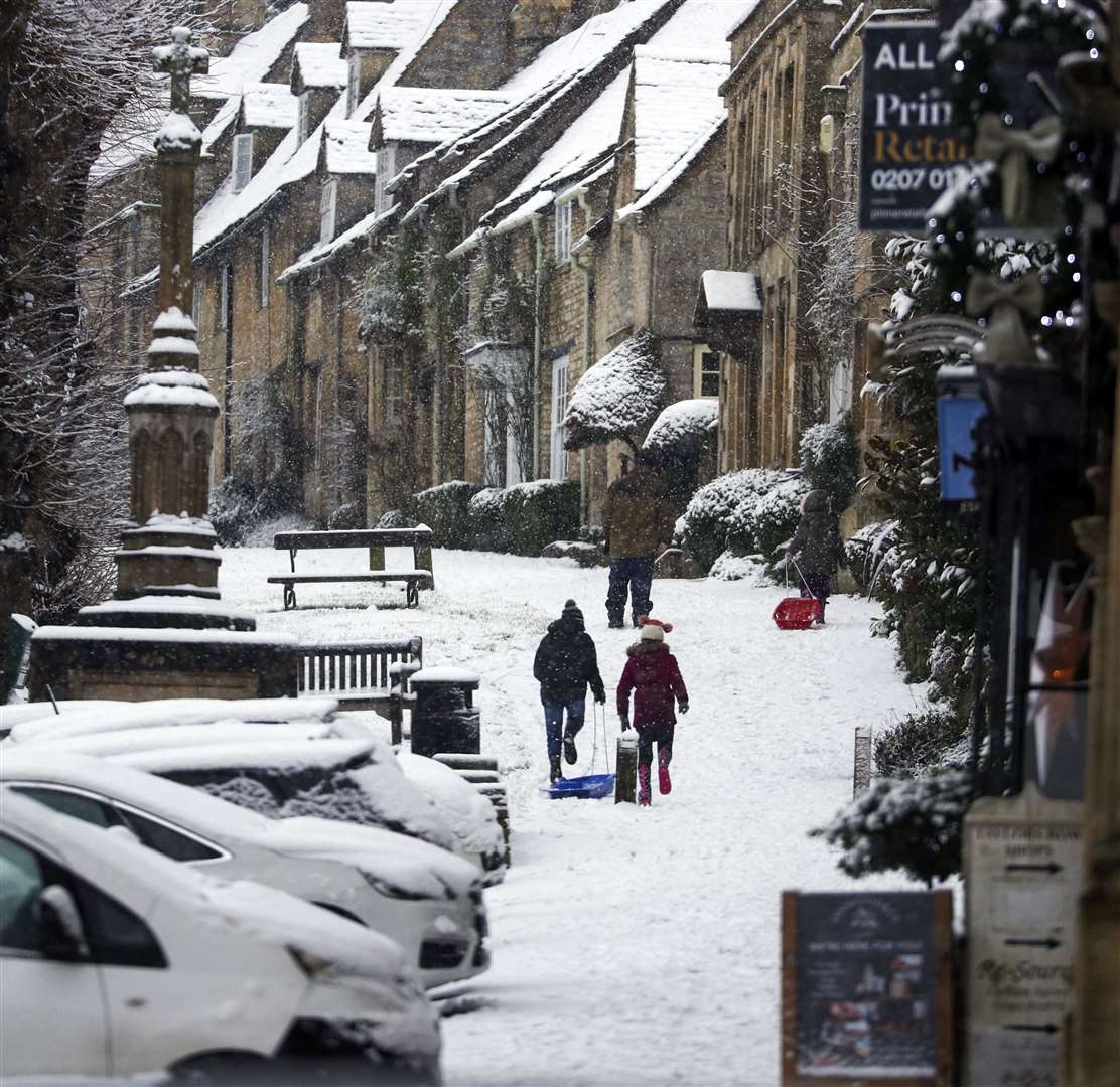 People sledge in the snow in Burford (Steve Parsons/PA)