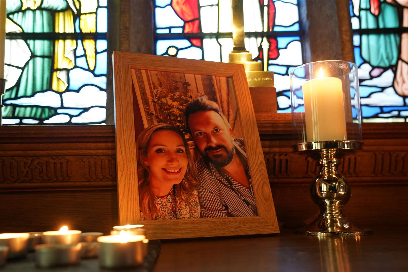 Candles are lit around a photo of Nicola Bulley and her partner Paul Ansell on an altar at St Michael’s Church in St Michael’s on Wyre (PA)