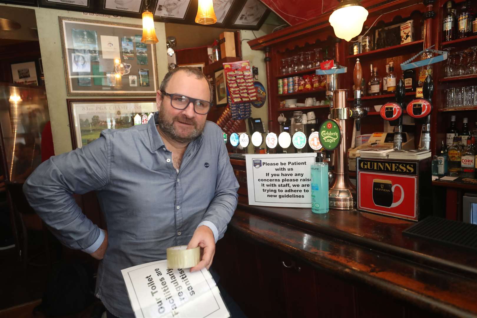 Niall Lawless, the owner of Mary Mac’s pub in Dublin, putting up social distancing signs in preparation for customers returning (Niall Carson/PA)