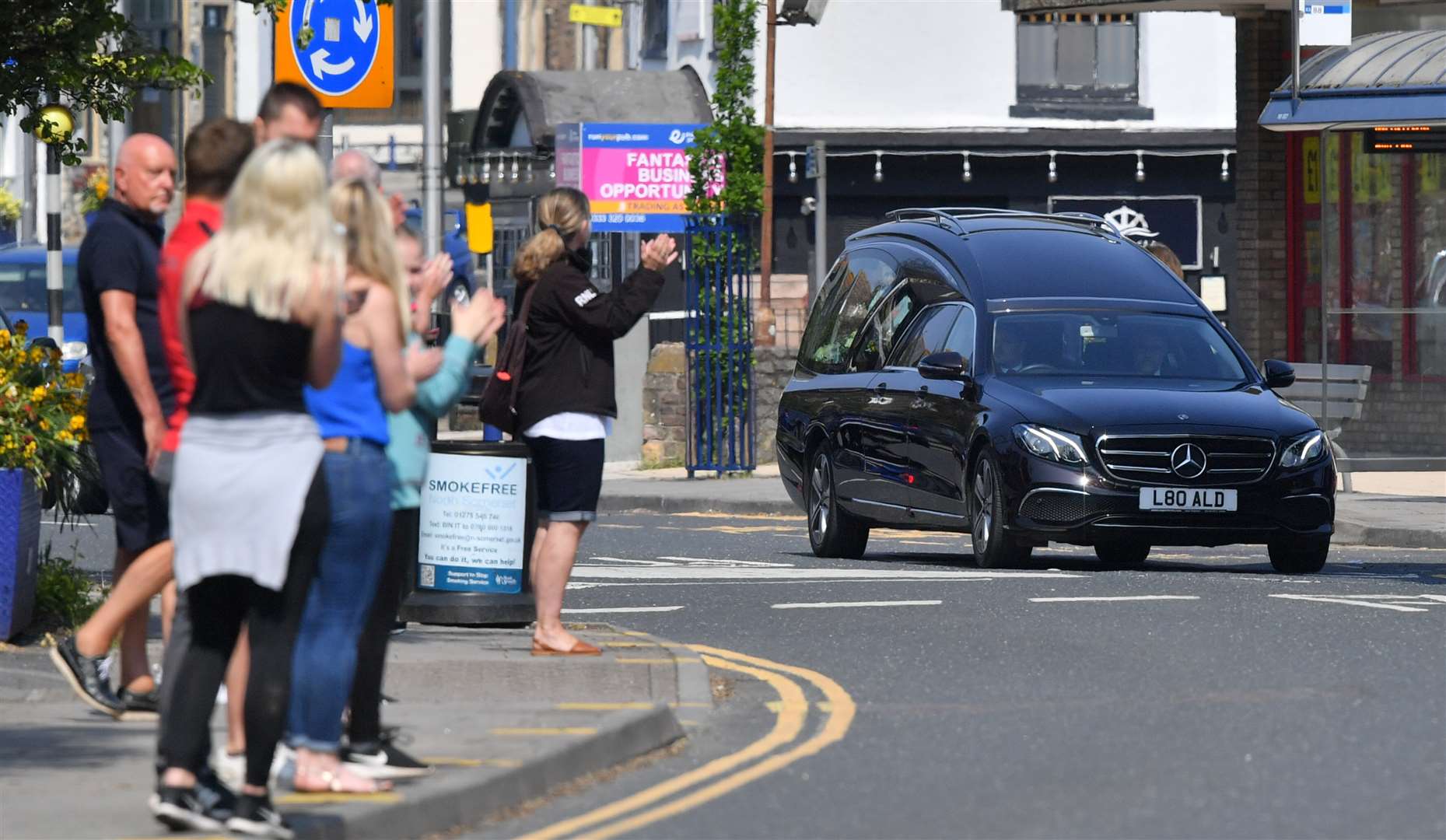 Wellwishers applaud the hearse carrying Eddie Large through the streets of Portishead (Ben Birchall/PA)