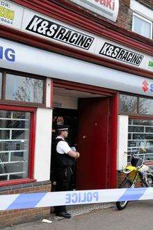 A police officer stands guard outside K&amp;S Racing