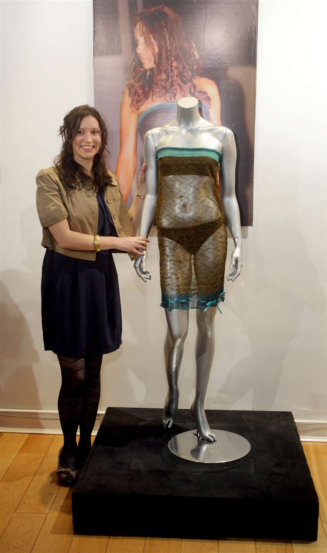 Designer Charlotte Todd stands by the transparent dress worn by Kate Middleton at a charity fashion show, watched by Prince William (Lewis Whyld/PA)