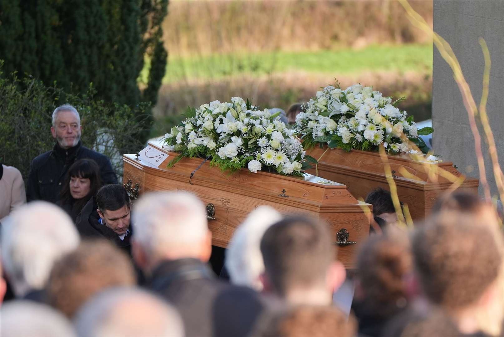 The coffins of father and son Peter and Loughlin Devlin, who died in a crash last Friday, are carried into the Church of St Joseph in Tynan for their funeral (Niall Carson/PA)